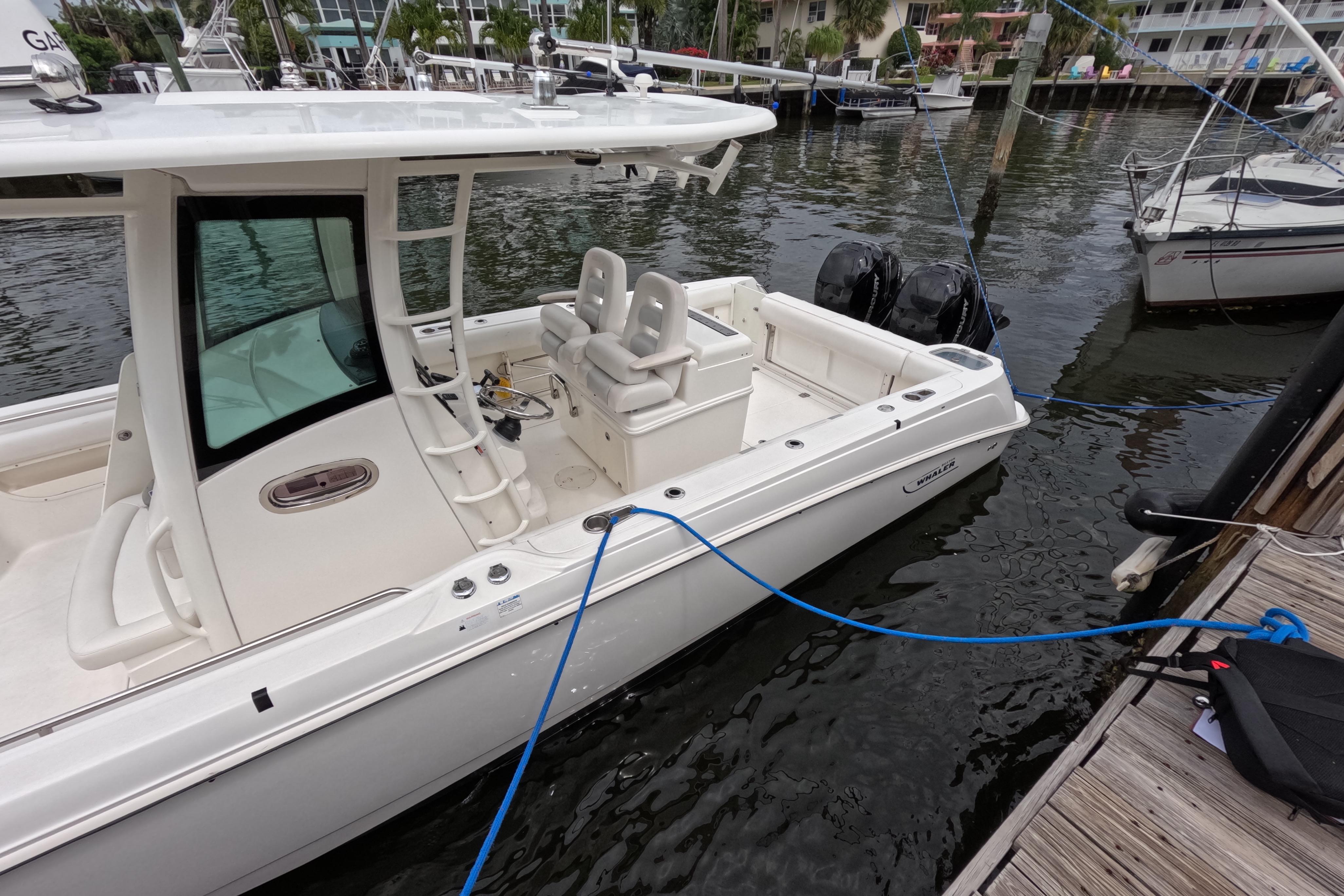 2013 Boston Whaler 320 Outrage docked at marina, side view.