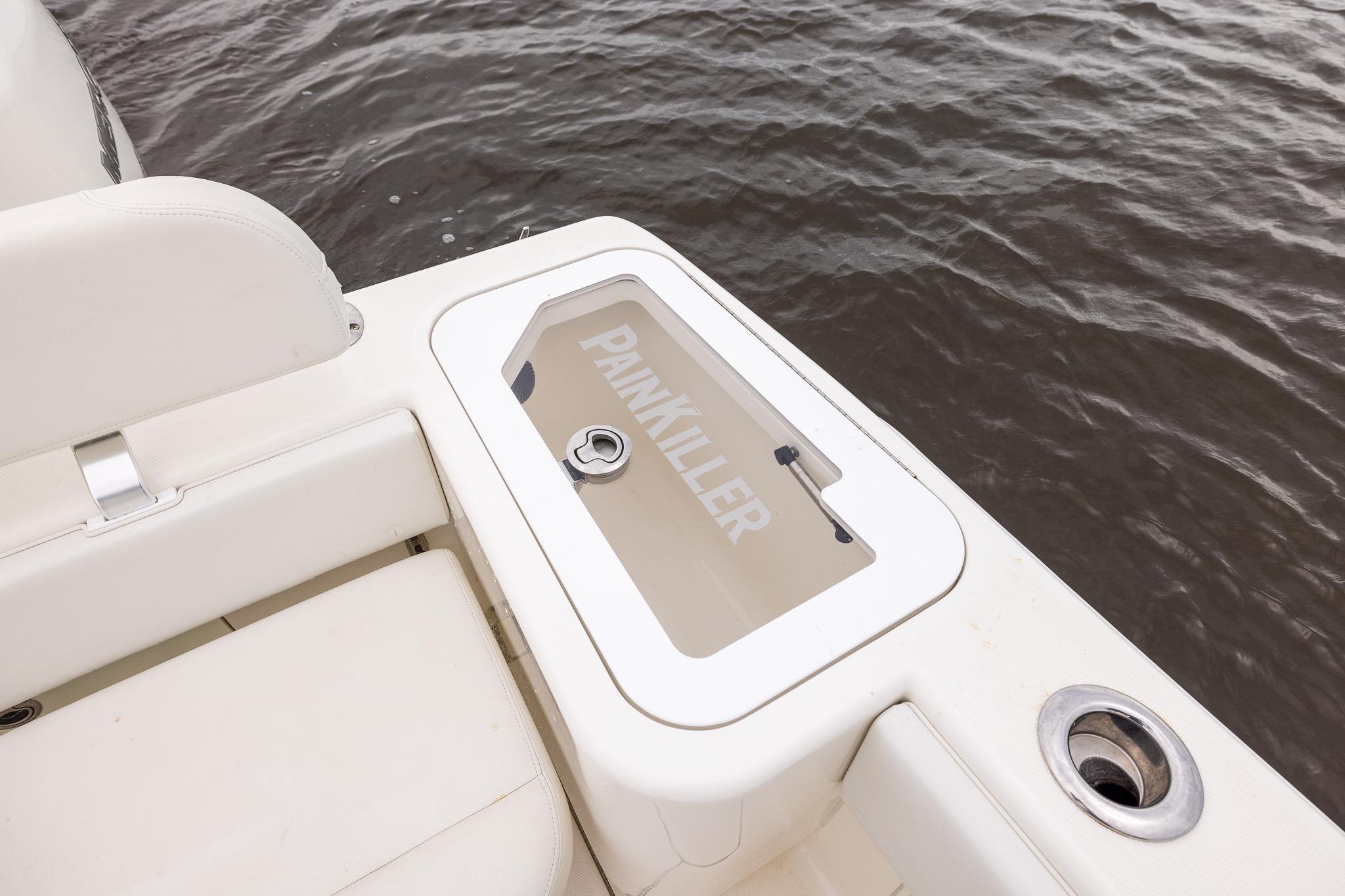 2019 SeaVee 322Z boat with "PAINKILLER" label on storage compartment by the water.