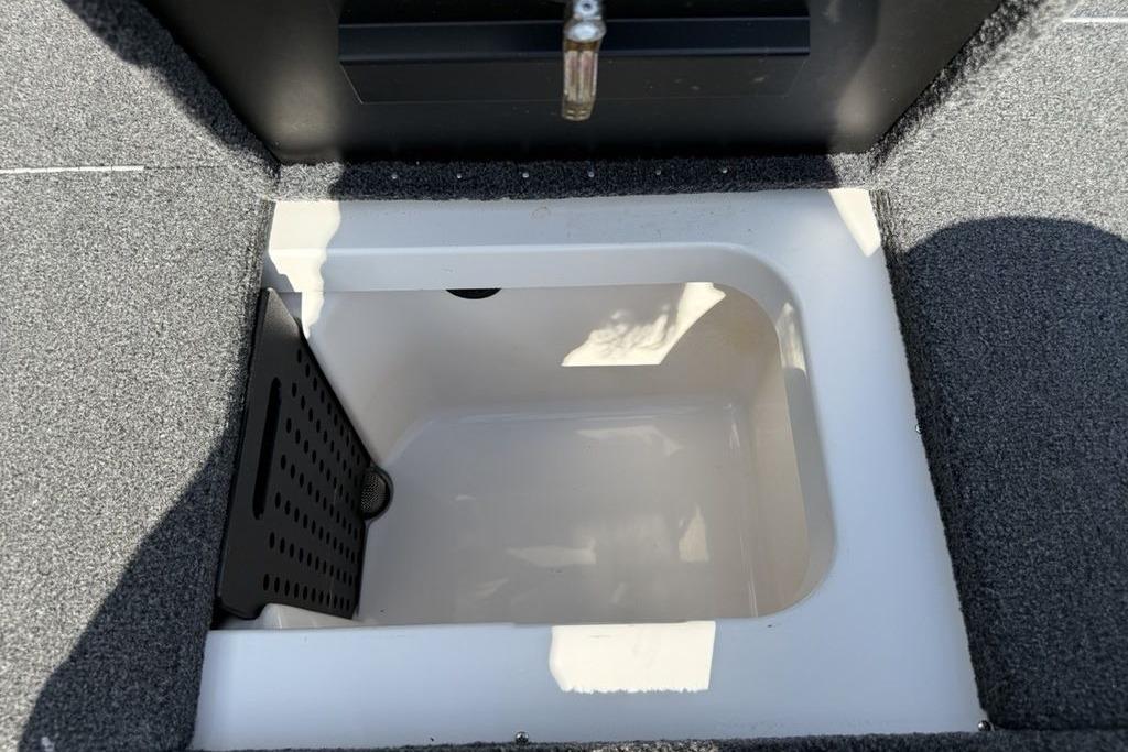 2023 Vexus AVX189 boat storage compartment with carpeted interior and drainage feature.