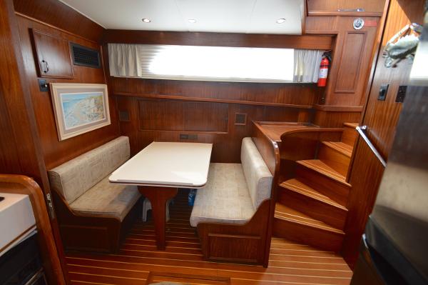 Interior of the 1980 Hatteras 53 Yacht Fisherman with wood paneling and a dining table.