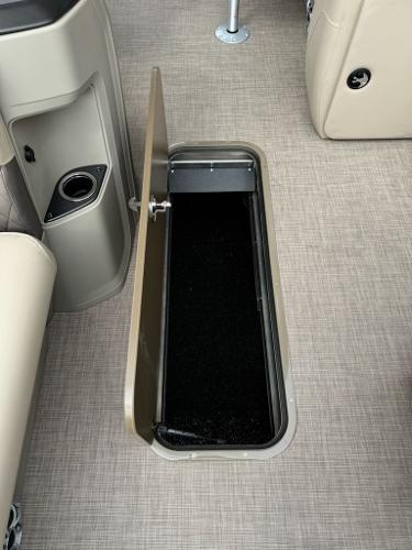 2025 Sun Tracker SportFish 22 XP3 boat storage compartment with open lid on beige flooring.