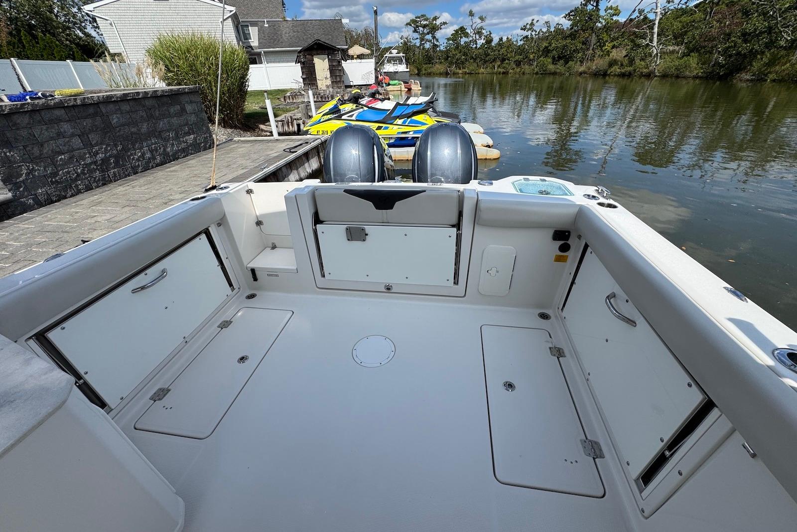 2022 Sailfish 276 DC boat interior with dual engines, docked by a serene waterway.