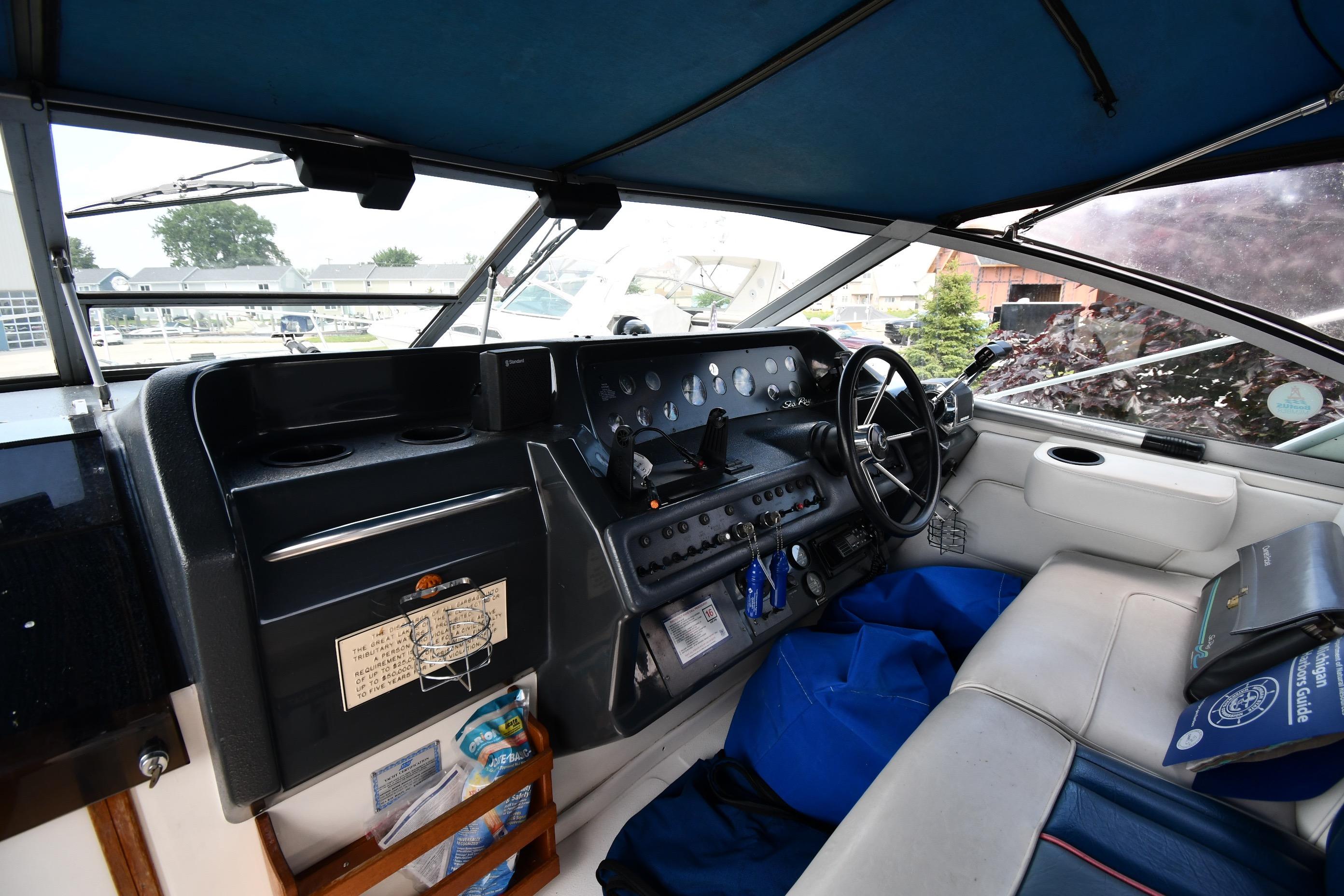 1993 Sea Ray 300 Sundancer cockpit with steering wheel, dashboard, and seating area.