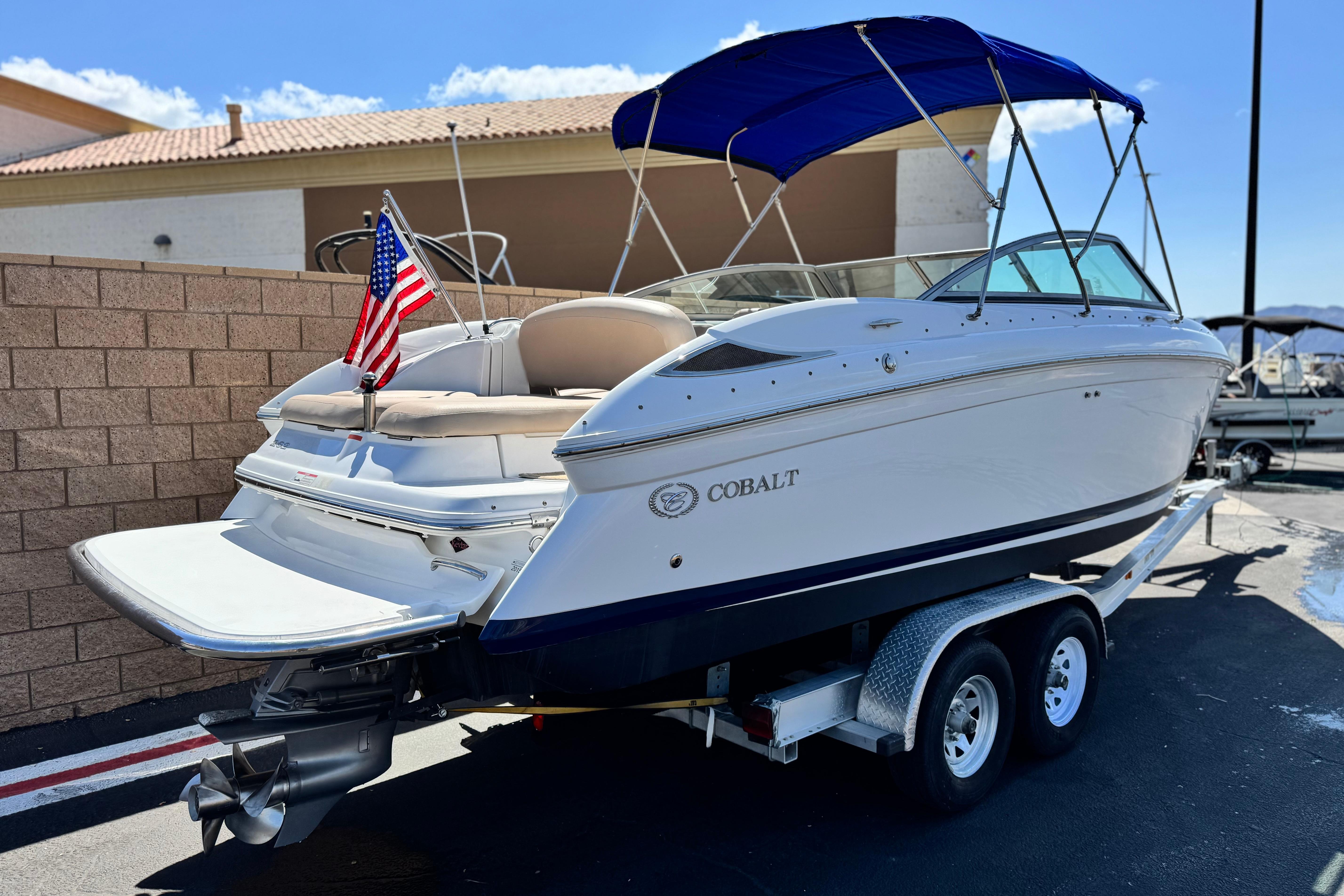 2008 Cobalt 262 boat on trailer with American flag and blue canopy.