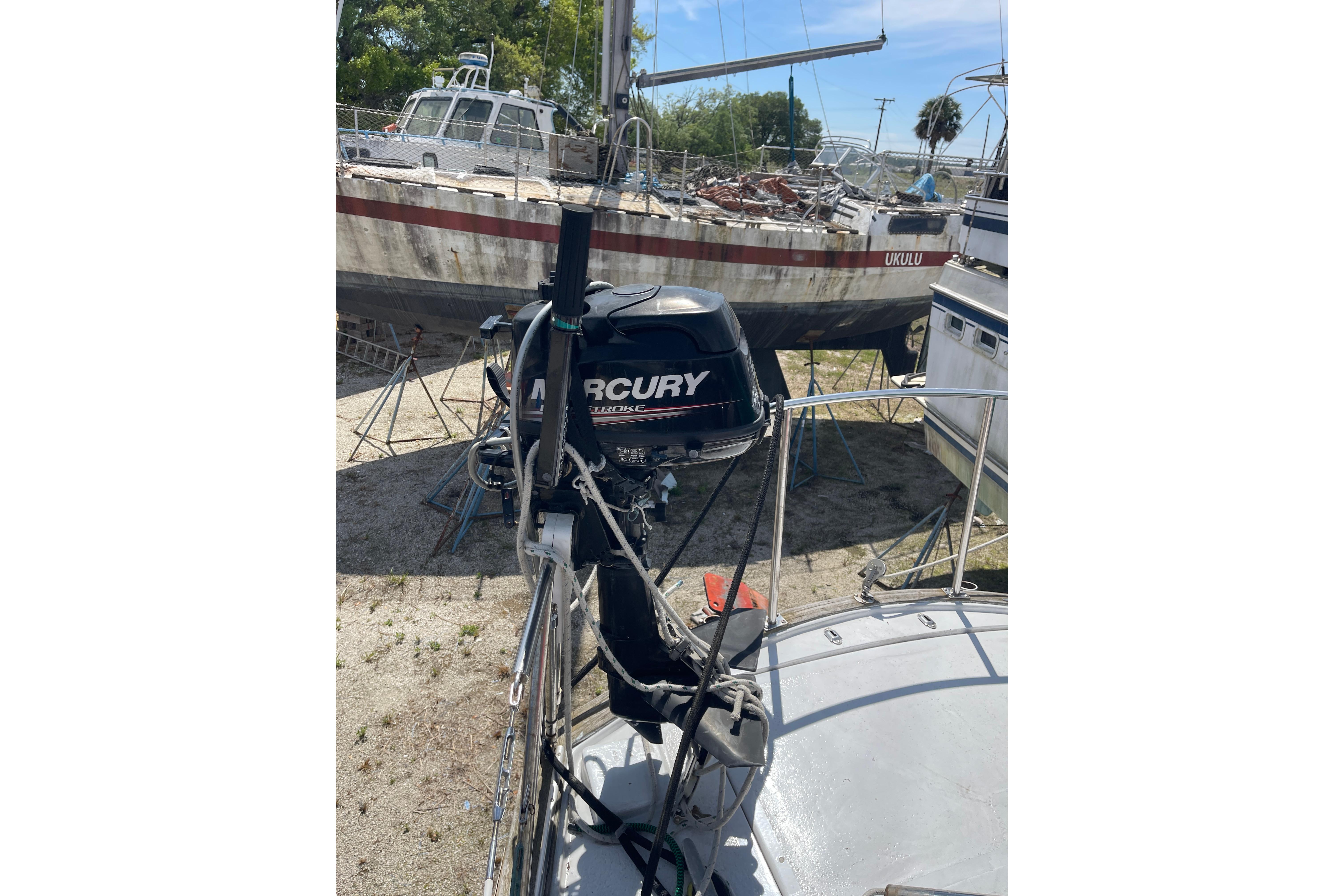 Sailboat with Mercury outboard motor, Irwin 37 Mk V model, docked on land.