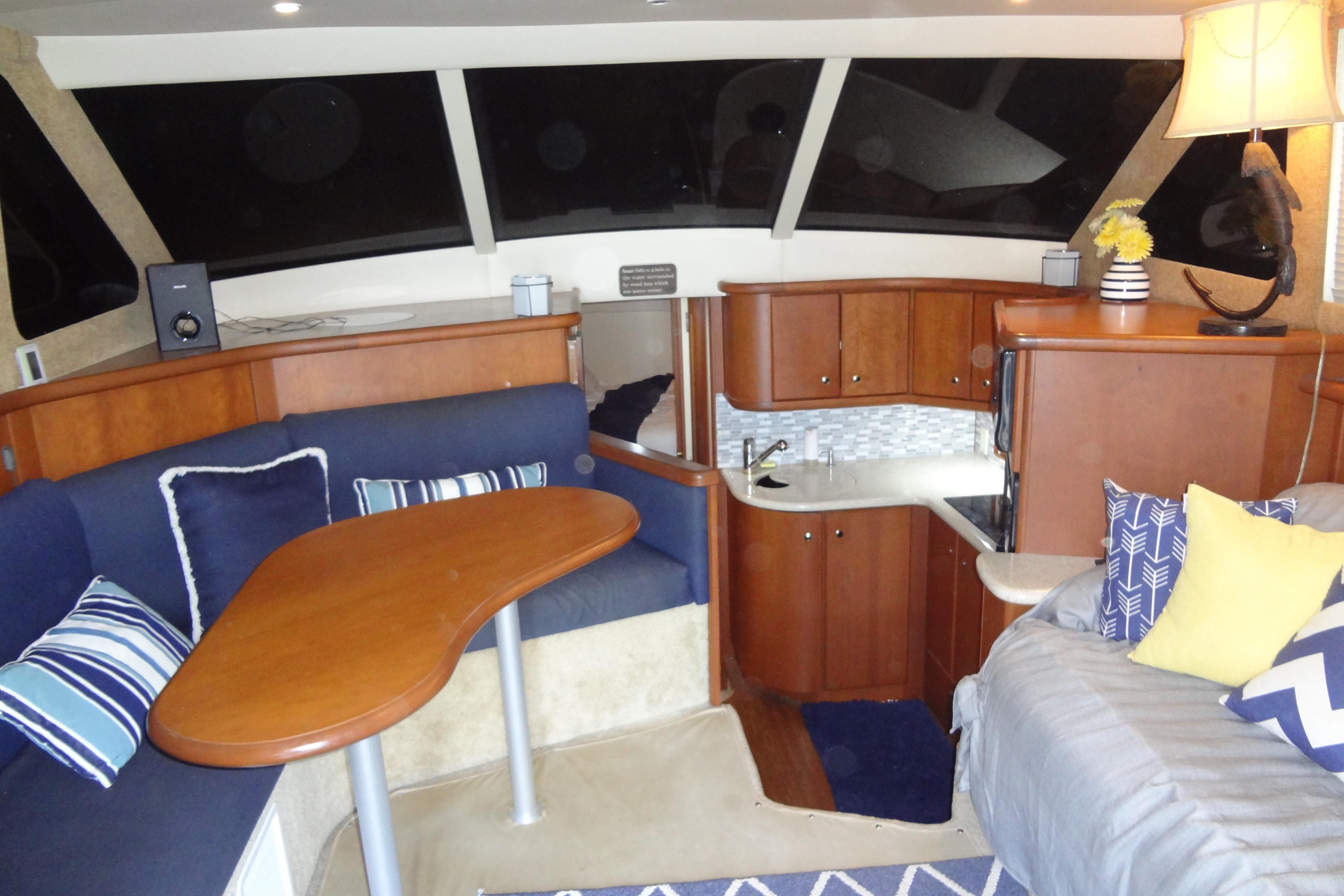 Interior of 2005 Silverton 34 Convertible yacht with cozy seating and modern kitchenette.