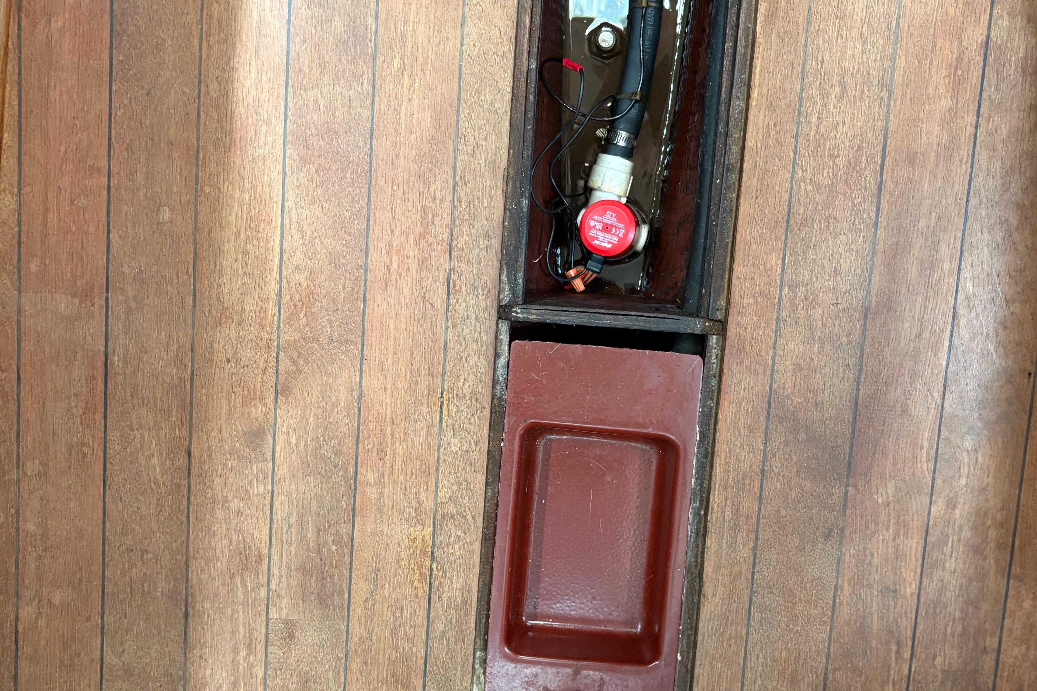 Wooden floor with open compartments on a 1981 Sabre 31 boat.