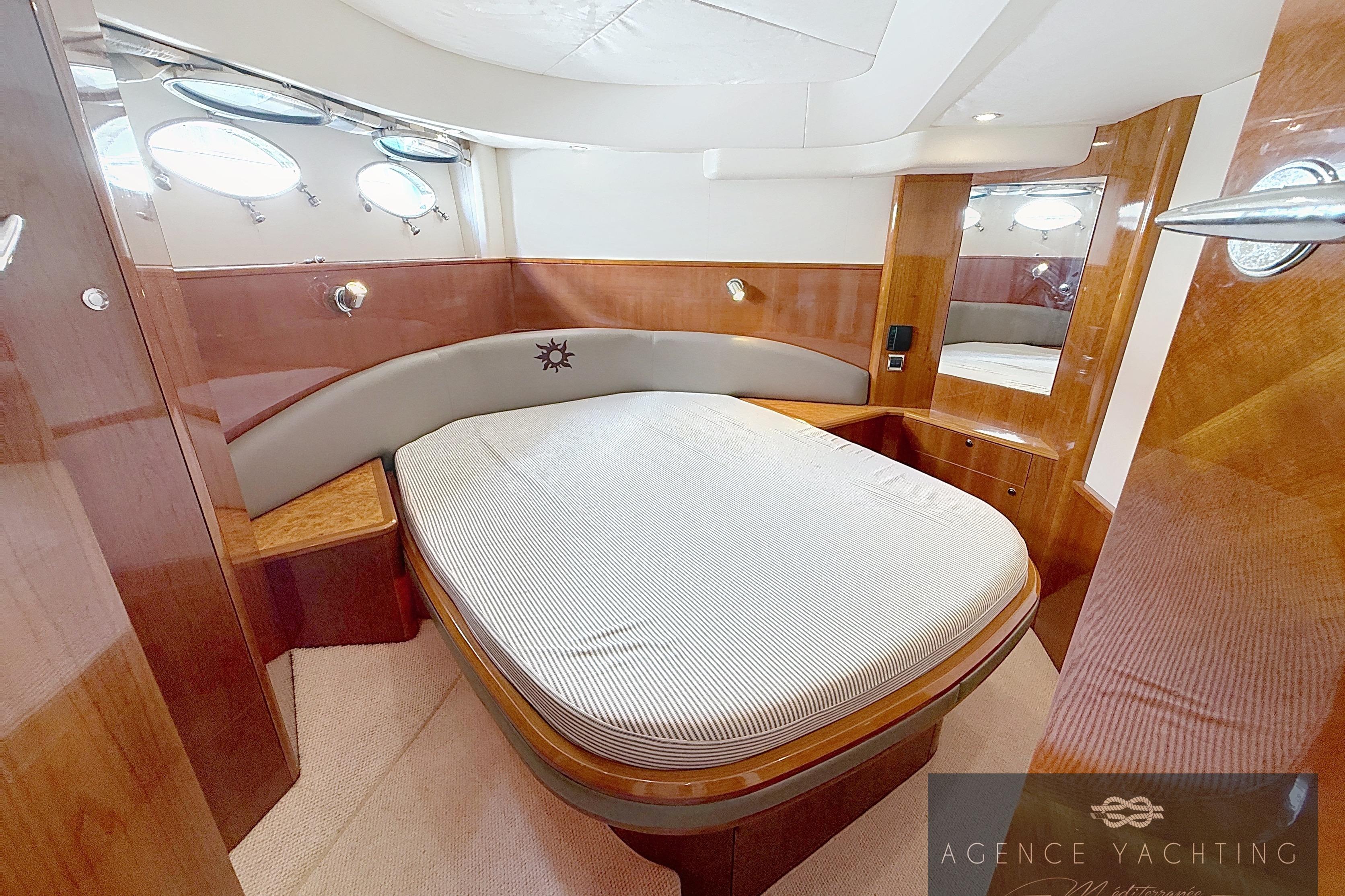 Luxurious 2004 Princess V58 yacht cabin with elegant wood finish and cozy bed.