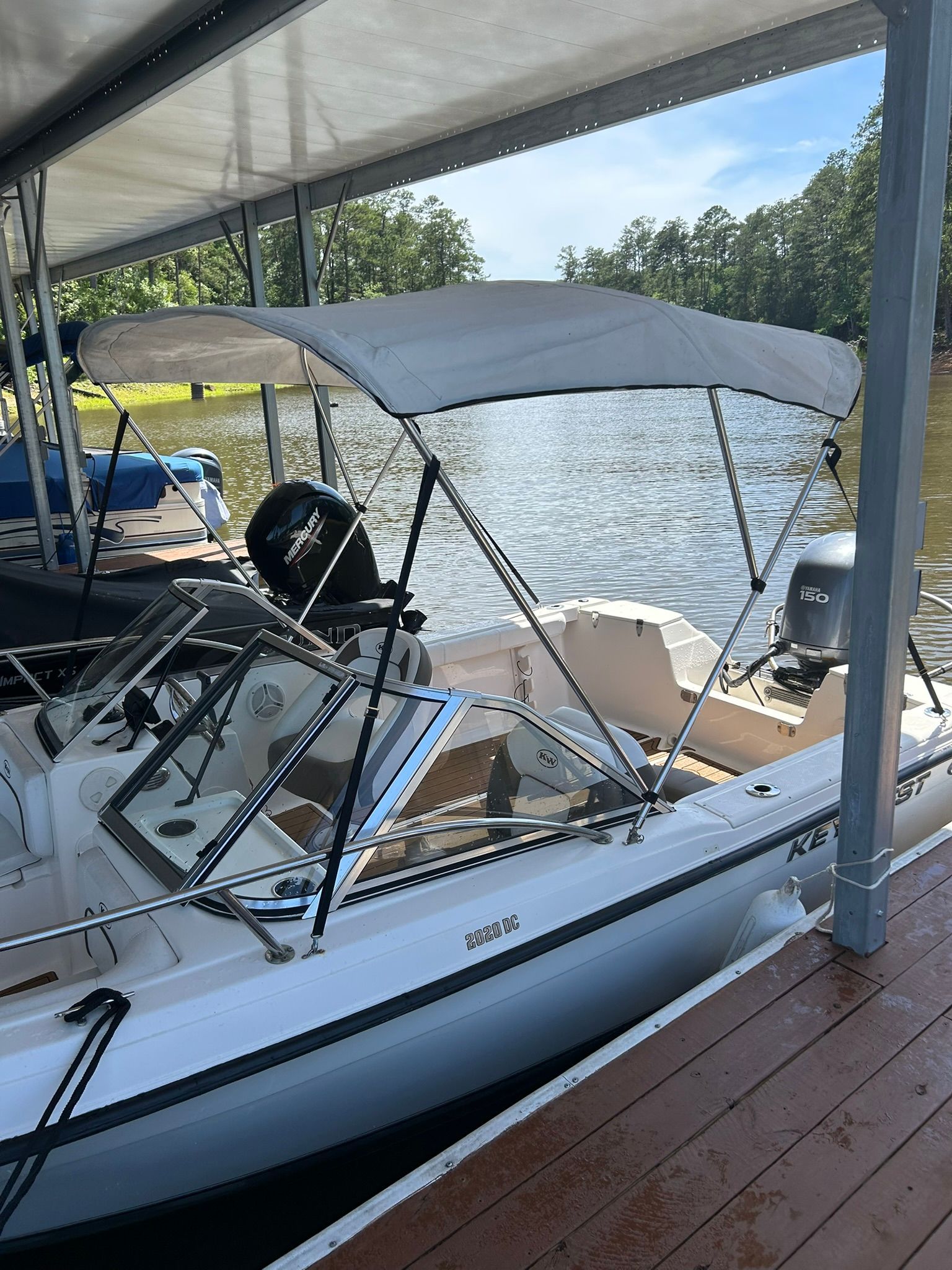 Key West 2020 Dual Console boat docked by calm water.