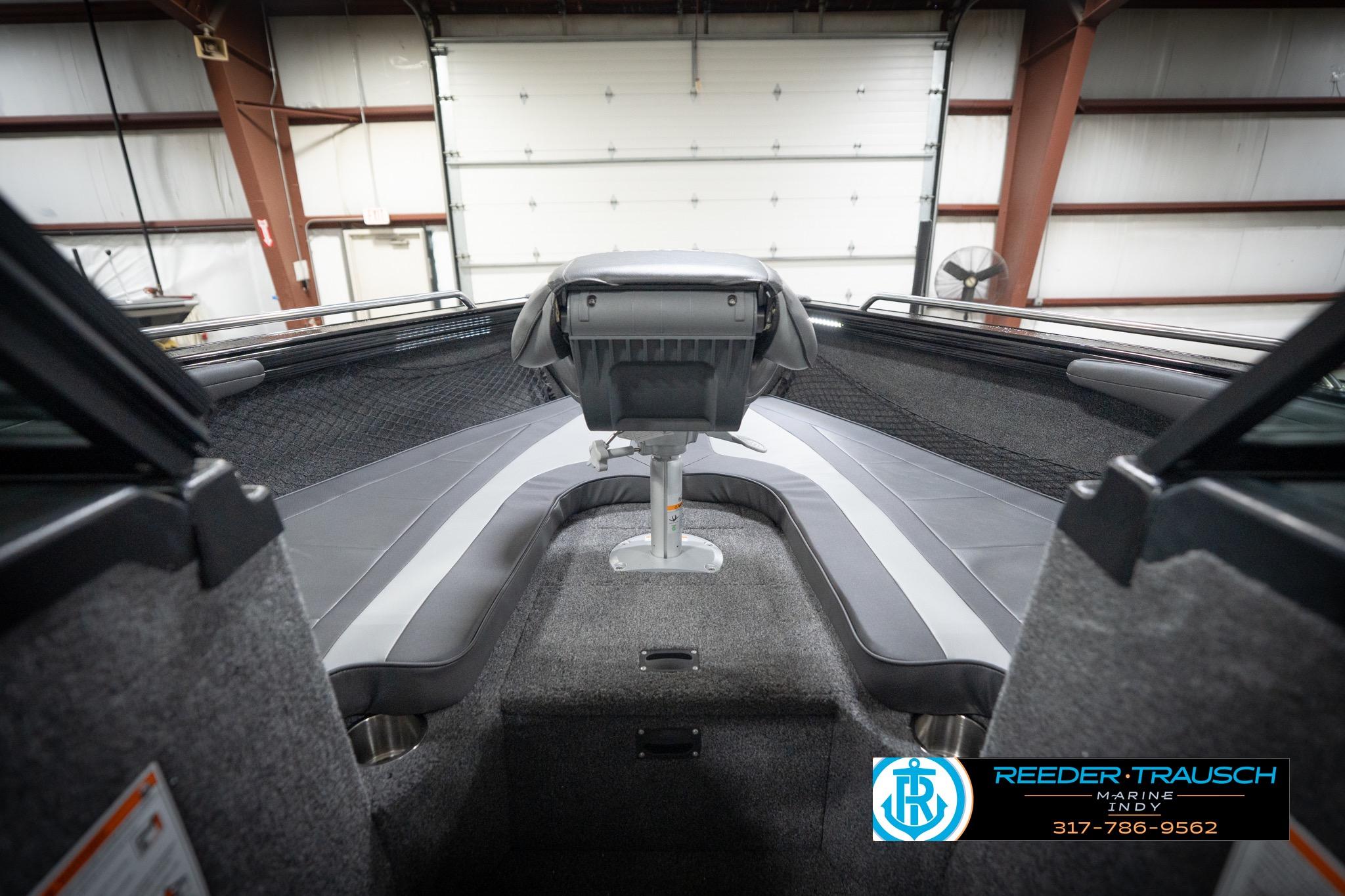 2026 Lund 2275 Baron boat interior with seating and steering, showcased in a showroom.