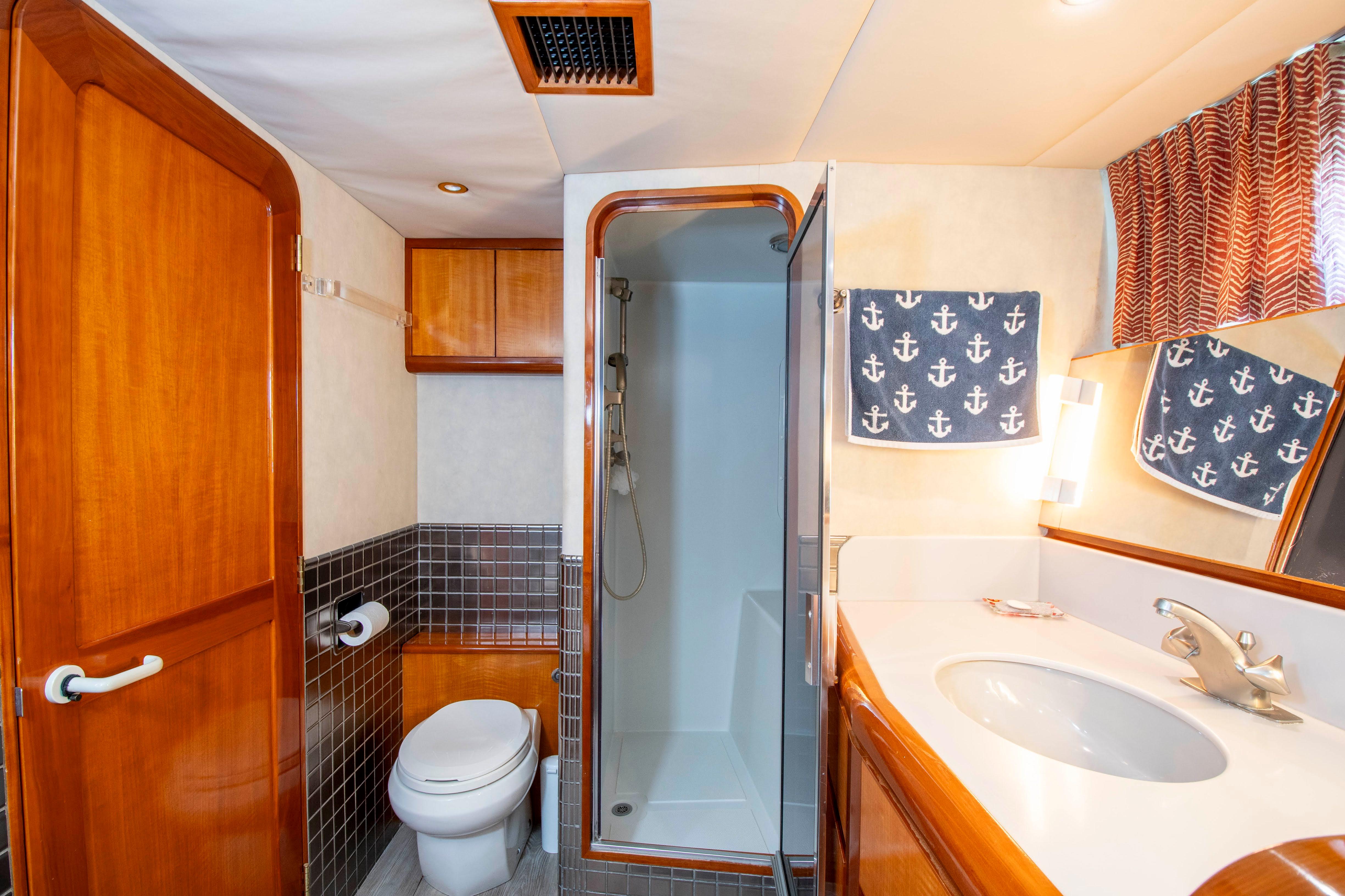 Luxurious 1988 Knight & Carver motoryacht bathroom with shower, sink, and nautical-themed decor.
