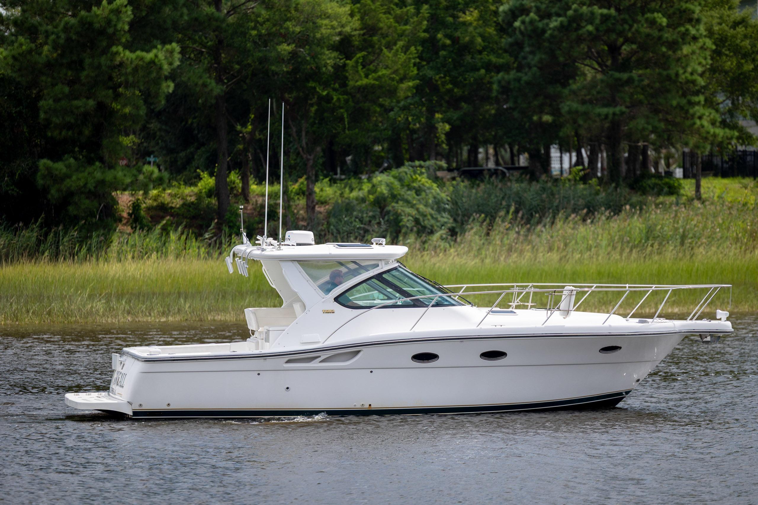 2004 Tiara Yachts 3200 Open cruising on a serene waterway, surrounded by lush greenery.