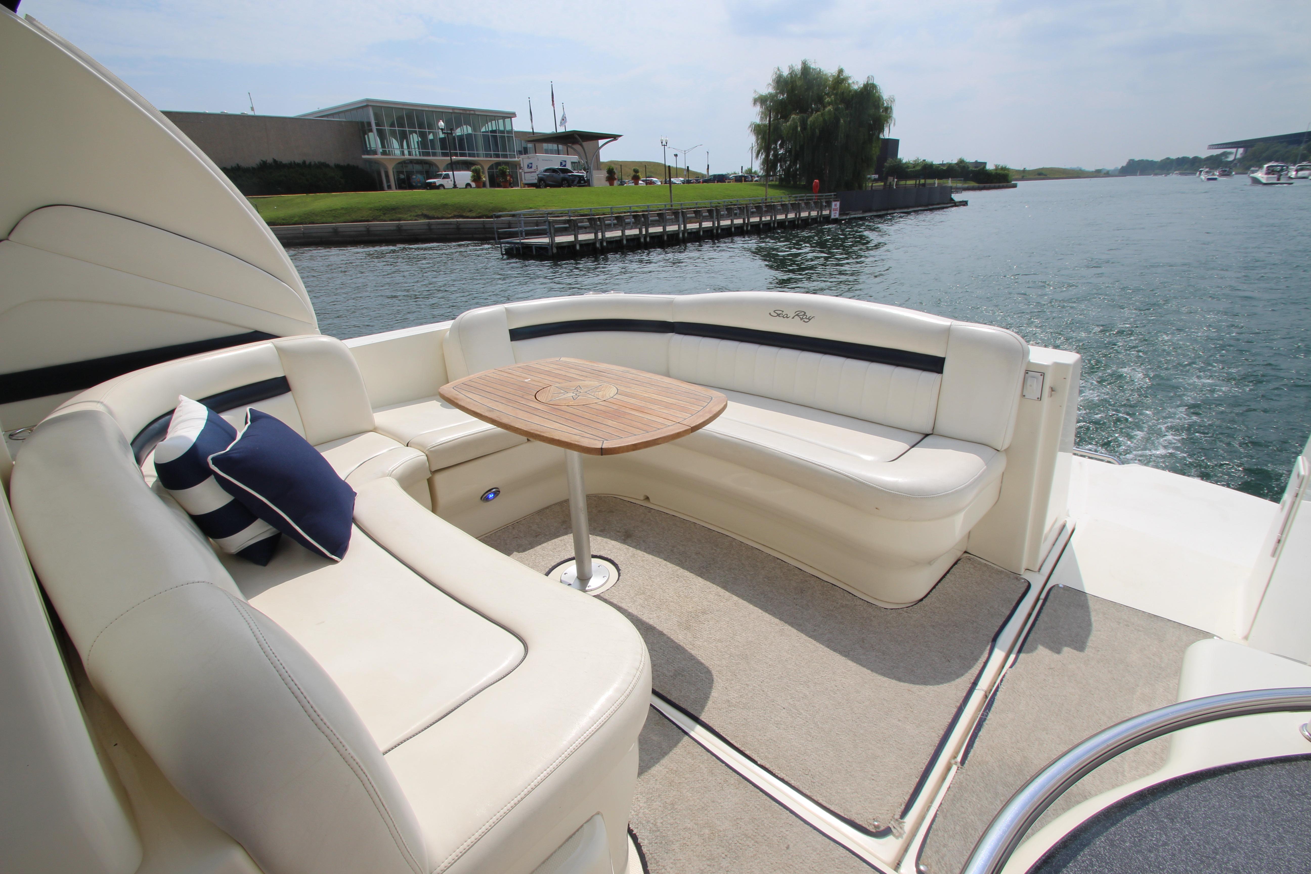 Luxurious 2004 Sea Ray 40 Sundancer yacht with elegant seating and scenic waterfront view.