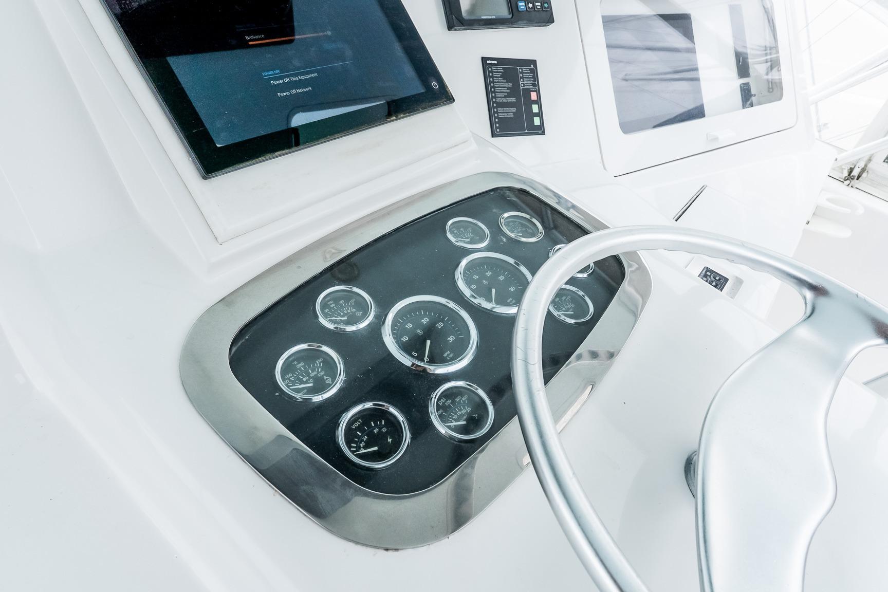 Control panel of a 2000 Viking 50' Convertible yacht with gauges and steering wheel.