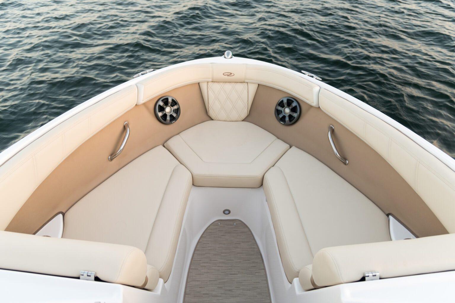 Luxurious seating on 2026 Regal 21 OBX boat, overlooking calm water.