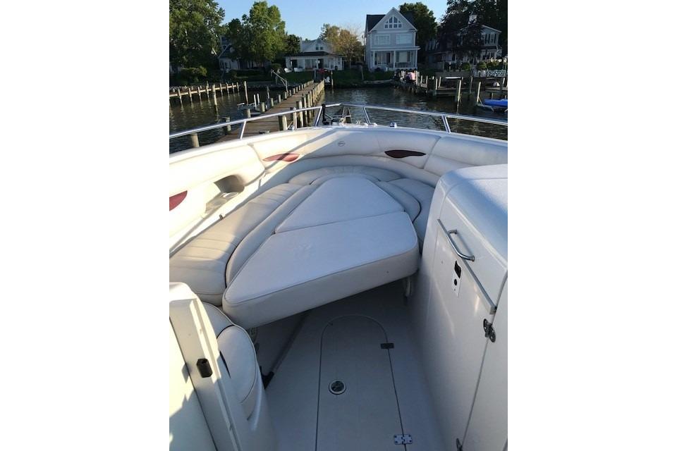 2004 Crownline 288 BR boat interior with white seating, docked near waterfront homes.