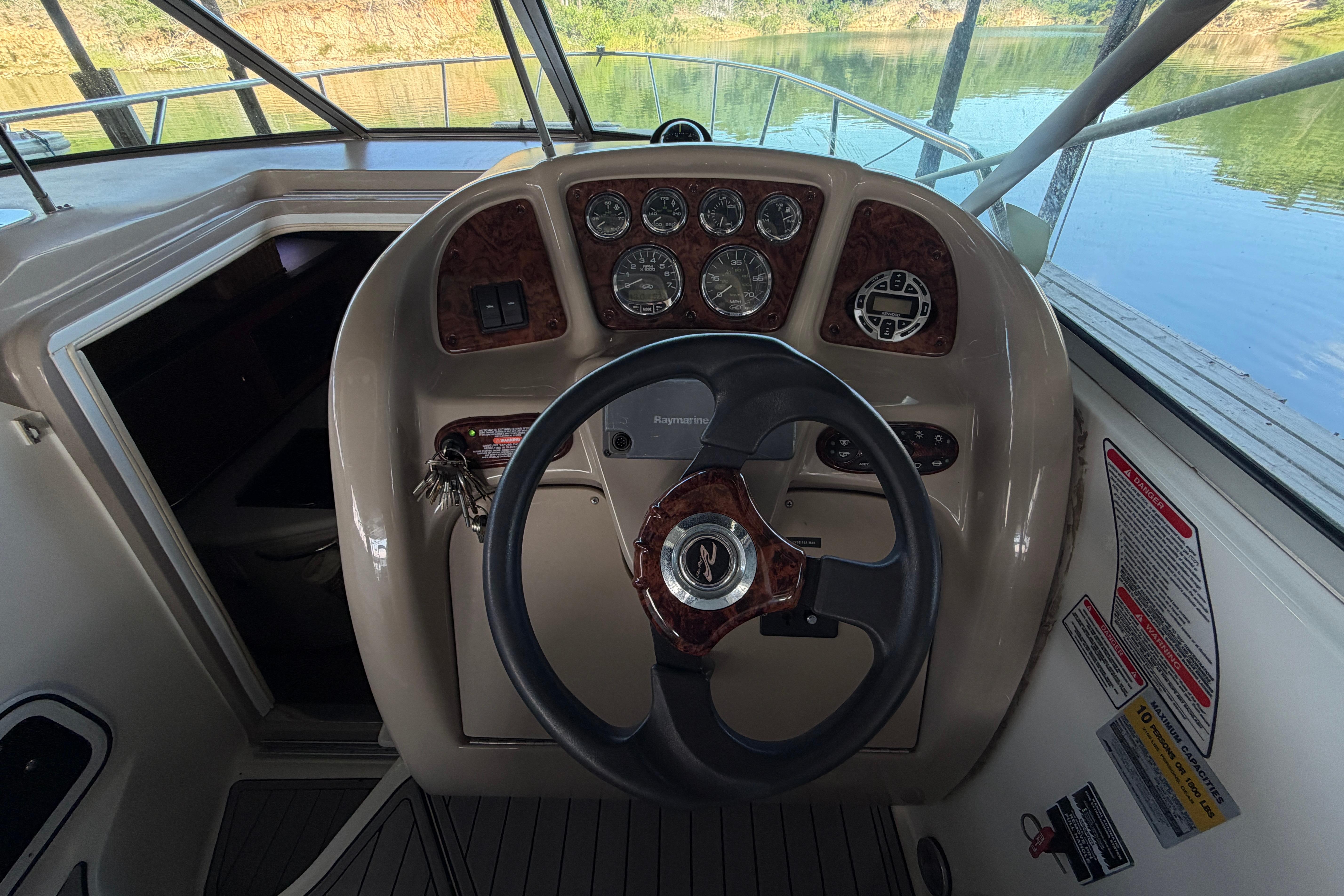 Steering console of a 2004 Sea Ray Sundancer 260 boat, featuring gauges and controls.