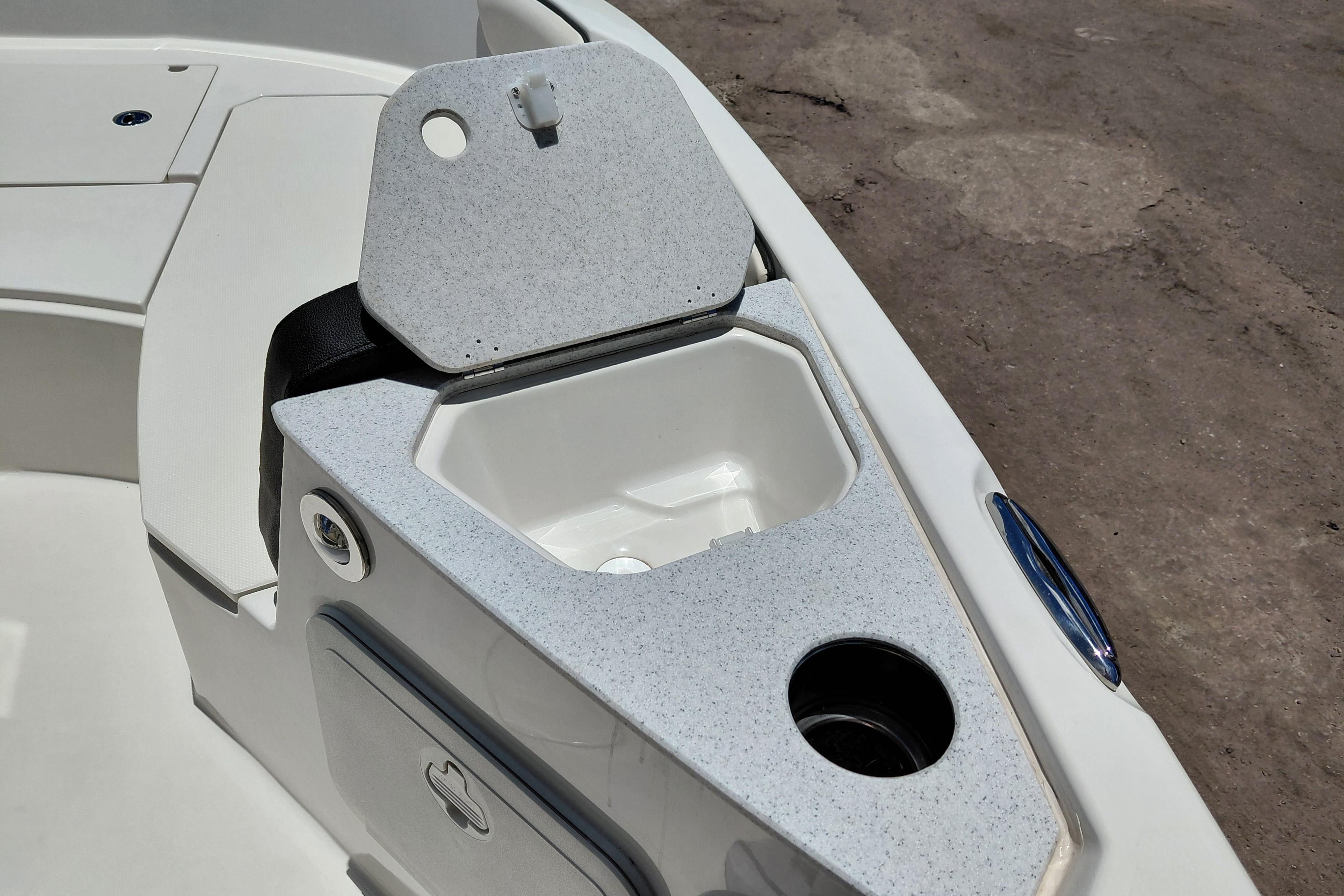 2023 Stingray 206 CC boat interior with open storage compartment and cup holder.