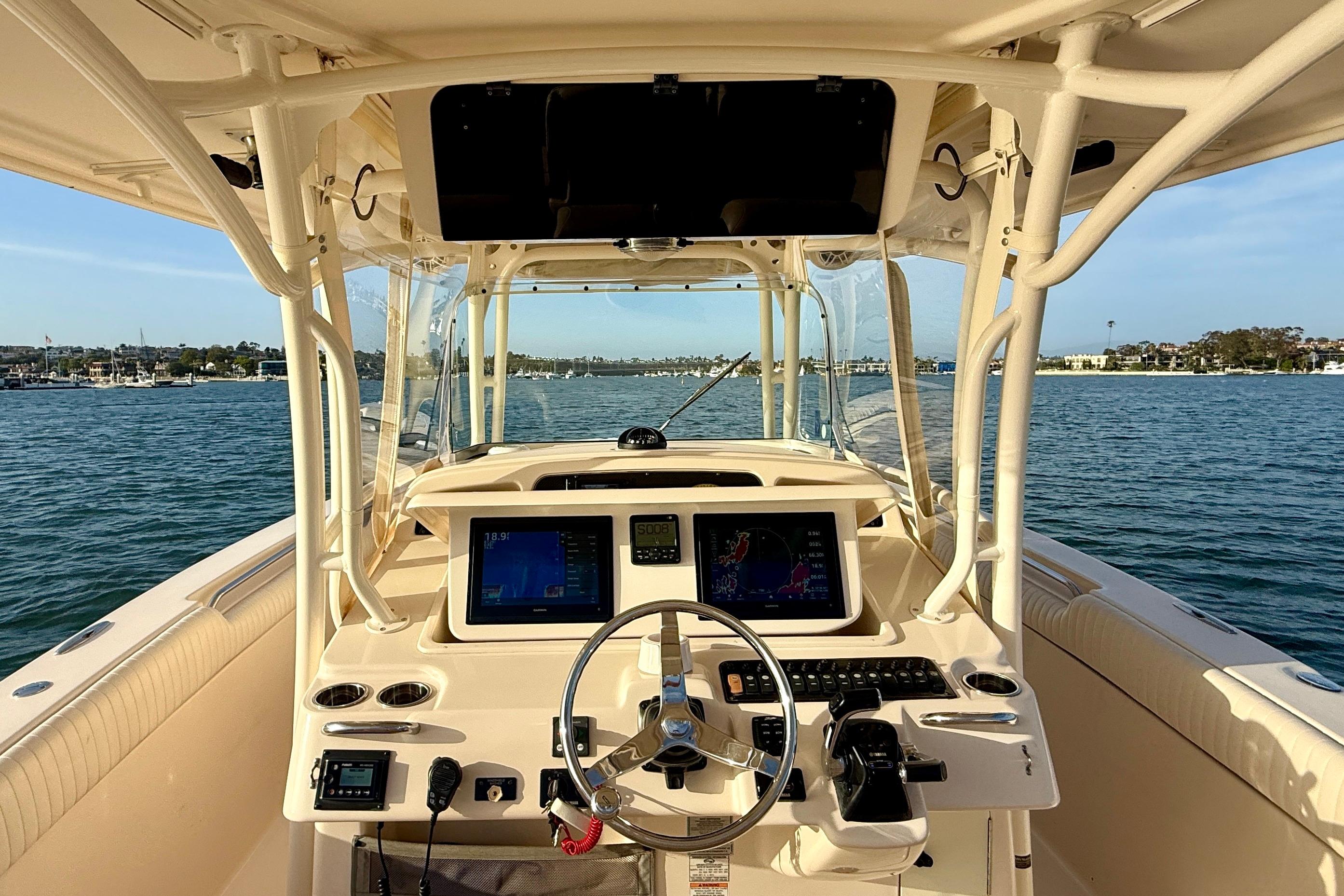2012 Grady-White Canyon 336 boat helm with dual displays, steering wheel, and ocean view.