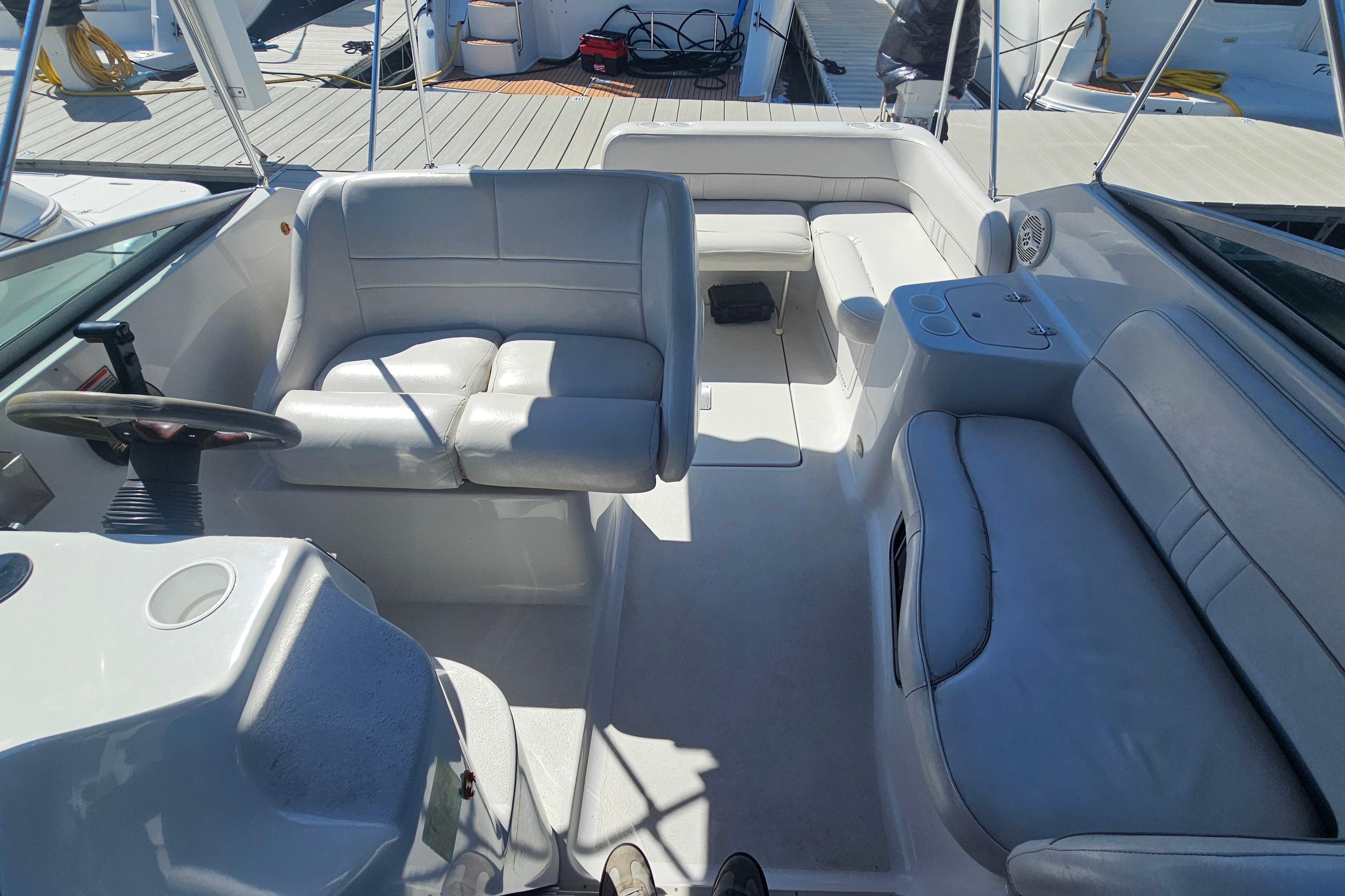 Interior of a 2000 Crownline 242 CR boat with seating and steering wheel.