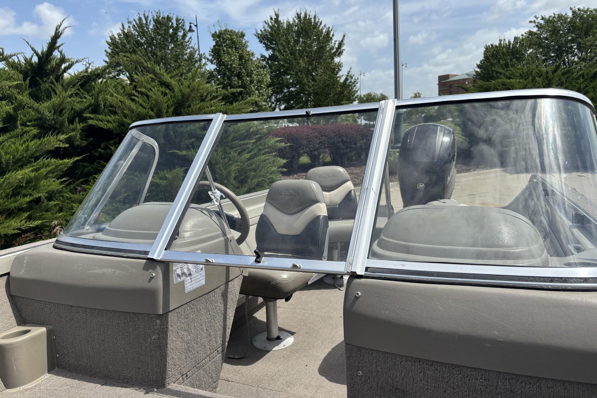 1999 Tracker Targa 18 boat with windshield and seating, parked outdoors.