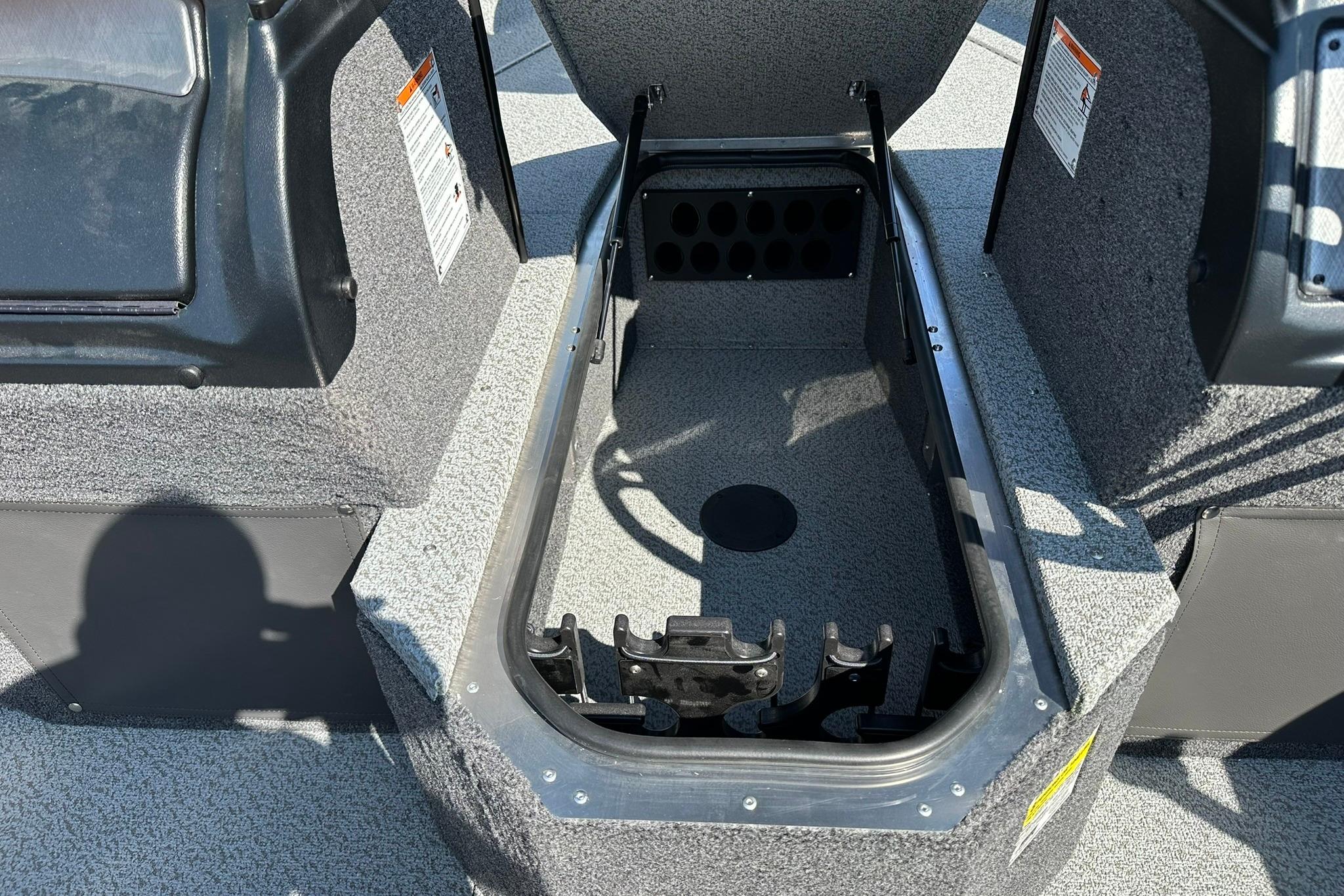 2026 Lund 1875 Fisherman boat storage compartment with open lid, showcasing interior space.