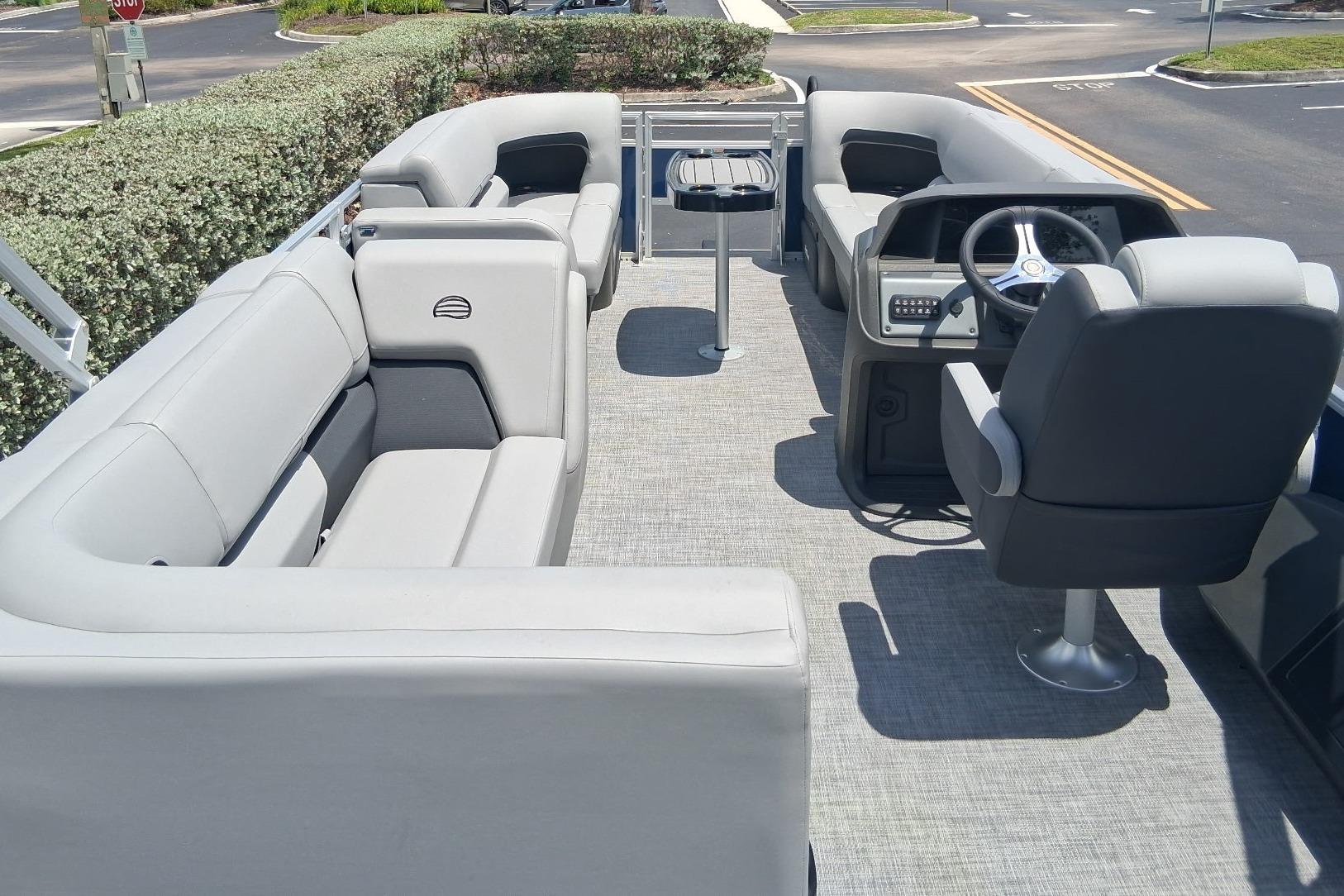 2026 Sun Tracker SportFish 22 DLX pontoon boat interior with seating and steering console.