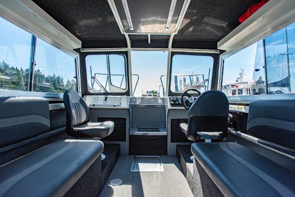 Interior of 2023 Spartan 220 Maximus Pro boat with seating and steering console.