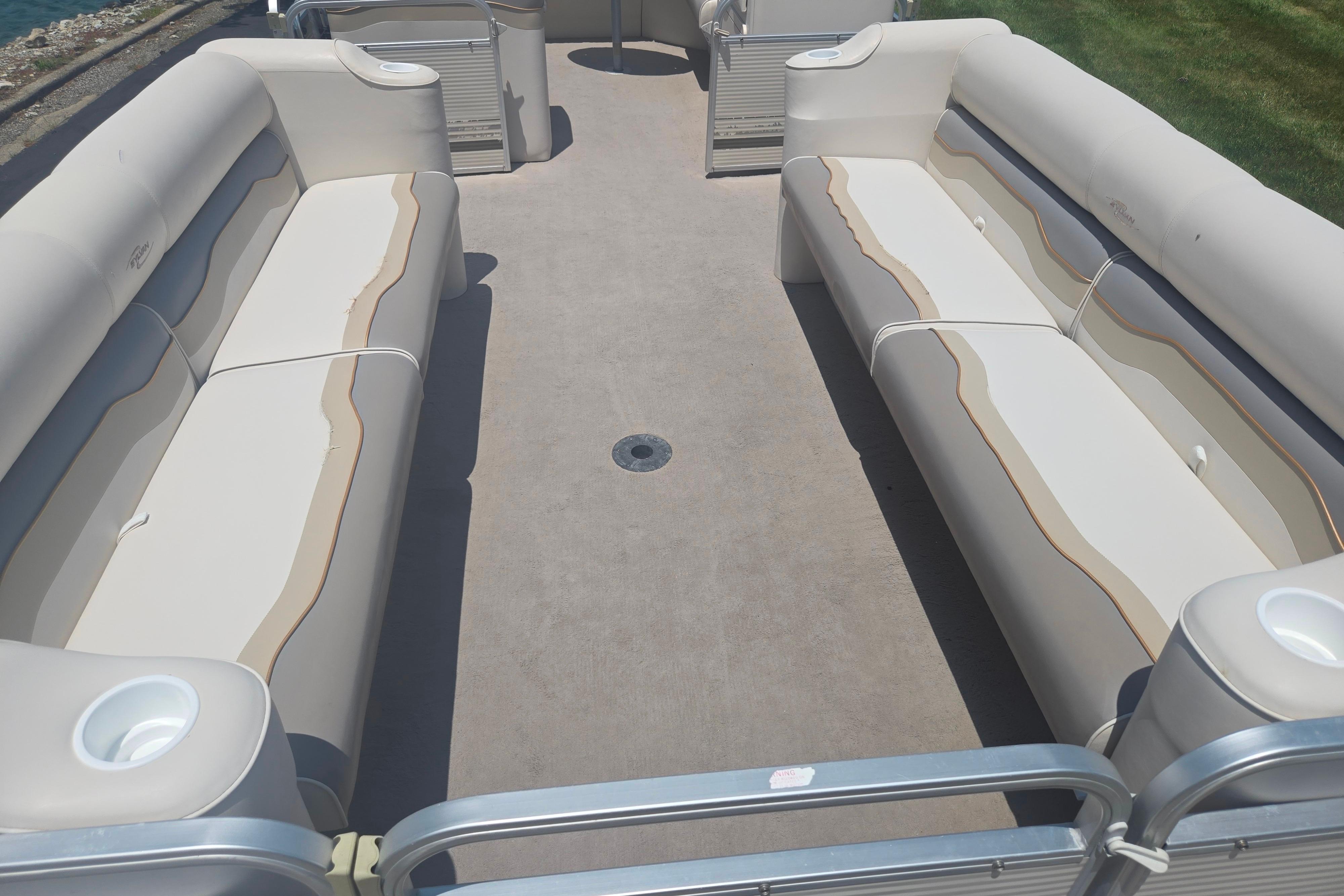 Interior view of a 2000 Sylvan 824 Elite Cruise pontoon boat with beige seating.
