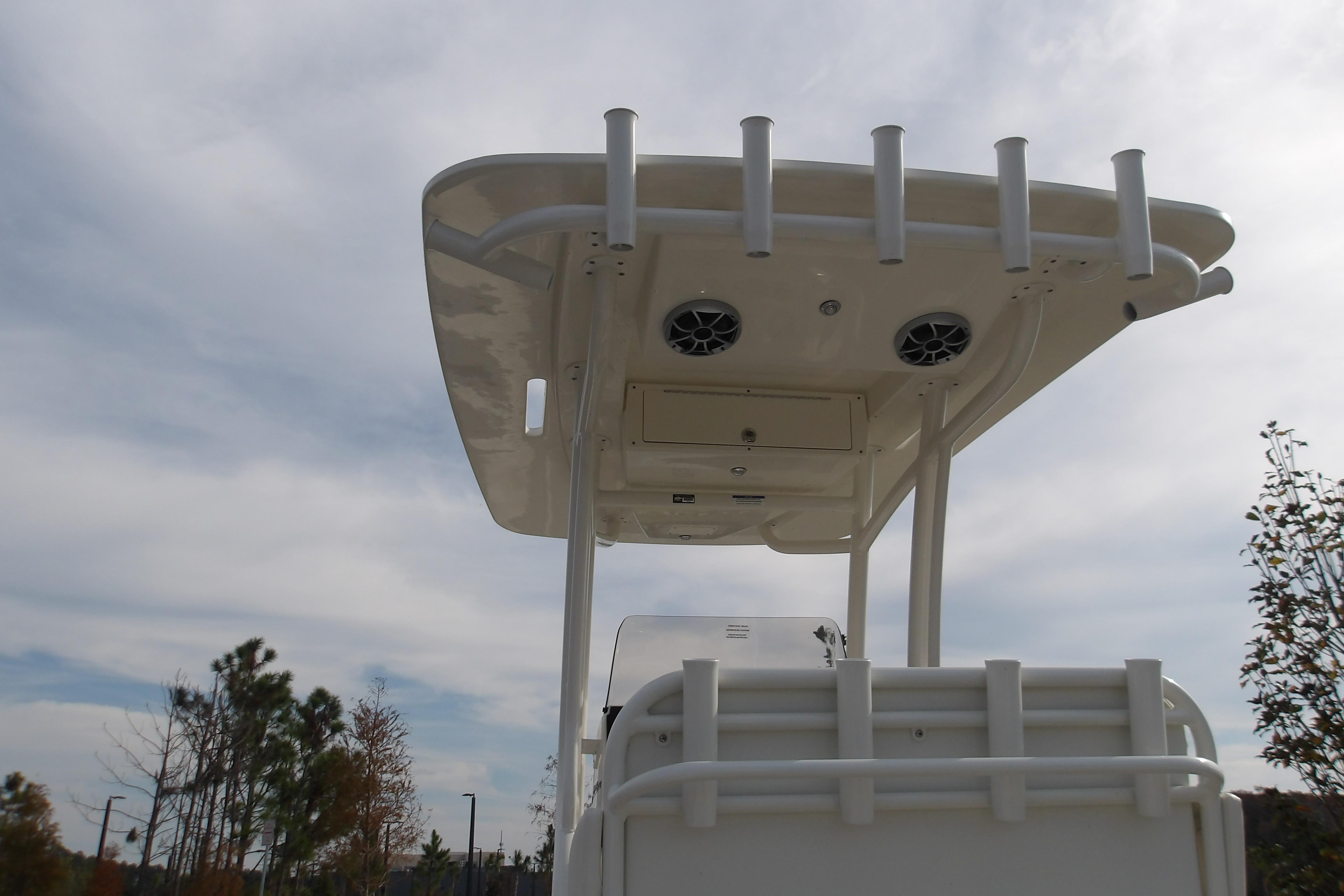 2026 Mako 24 APEX boat with T-top and rod holders against a cloudy sky.
