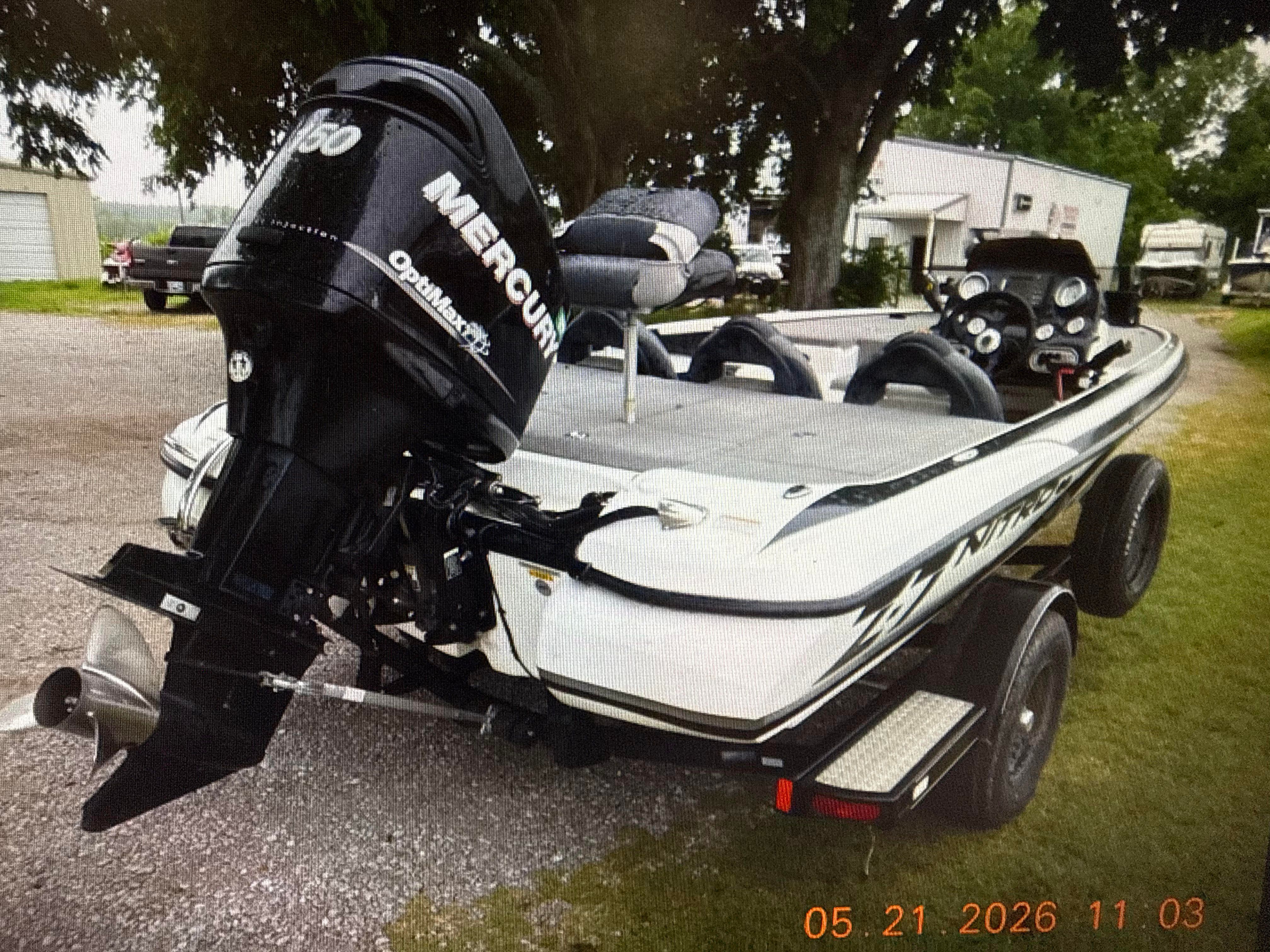 A 2011 Nitro Z-7 boat with a Mercury engine on a trailer, parked on a gravel lot.