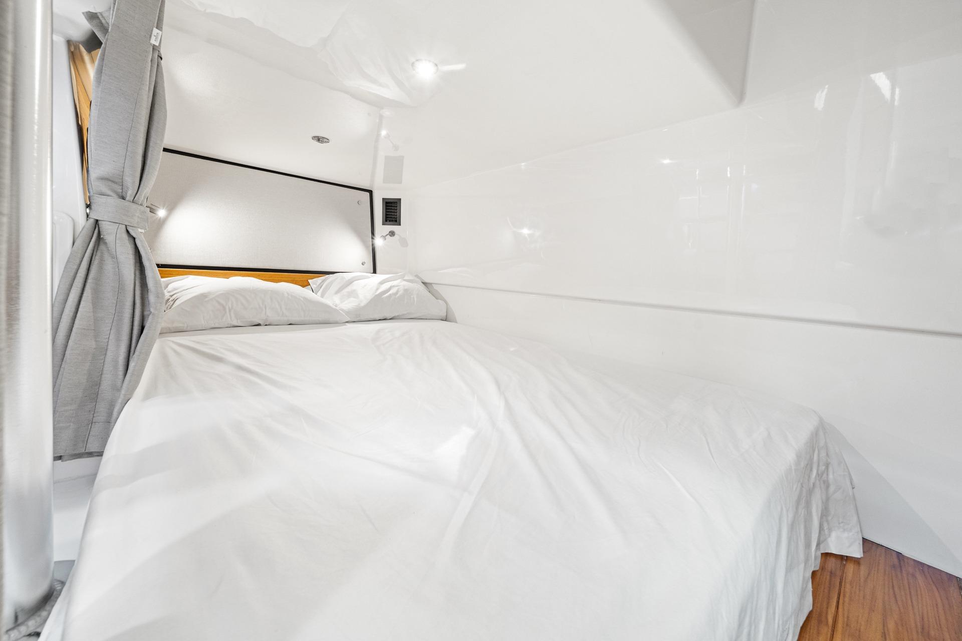 Luxurious cabin interior of 2024 Boston Whaler 405 Conquest with cozy bedding.