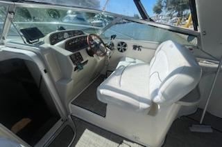 2000 Rinker Fiesta Vee 310 boat cockpit with white seating and modern dashboard controls.