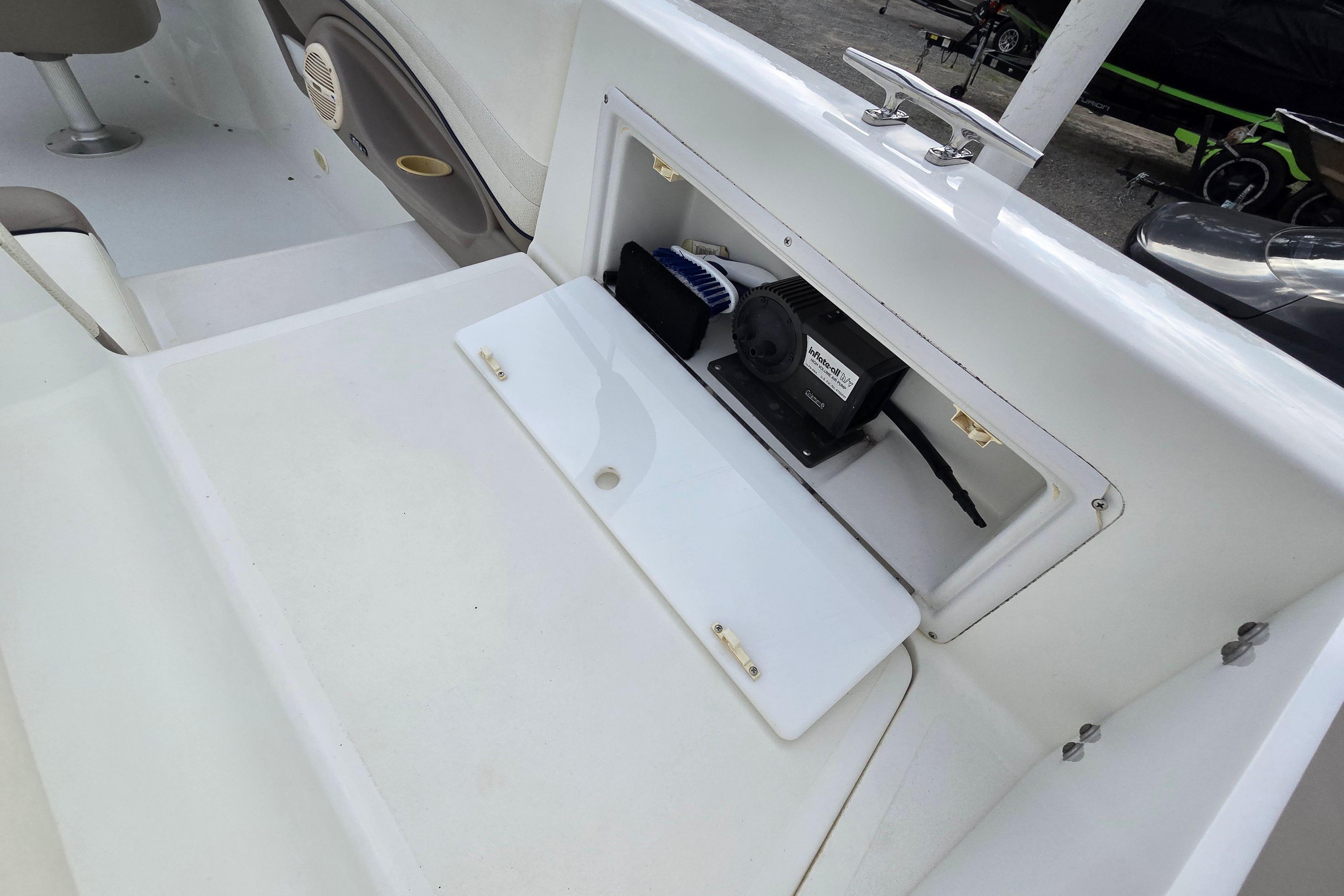 Storage compartment on a 2000 Cobalt 246 boat, featuring a white interior and equipment.