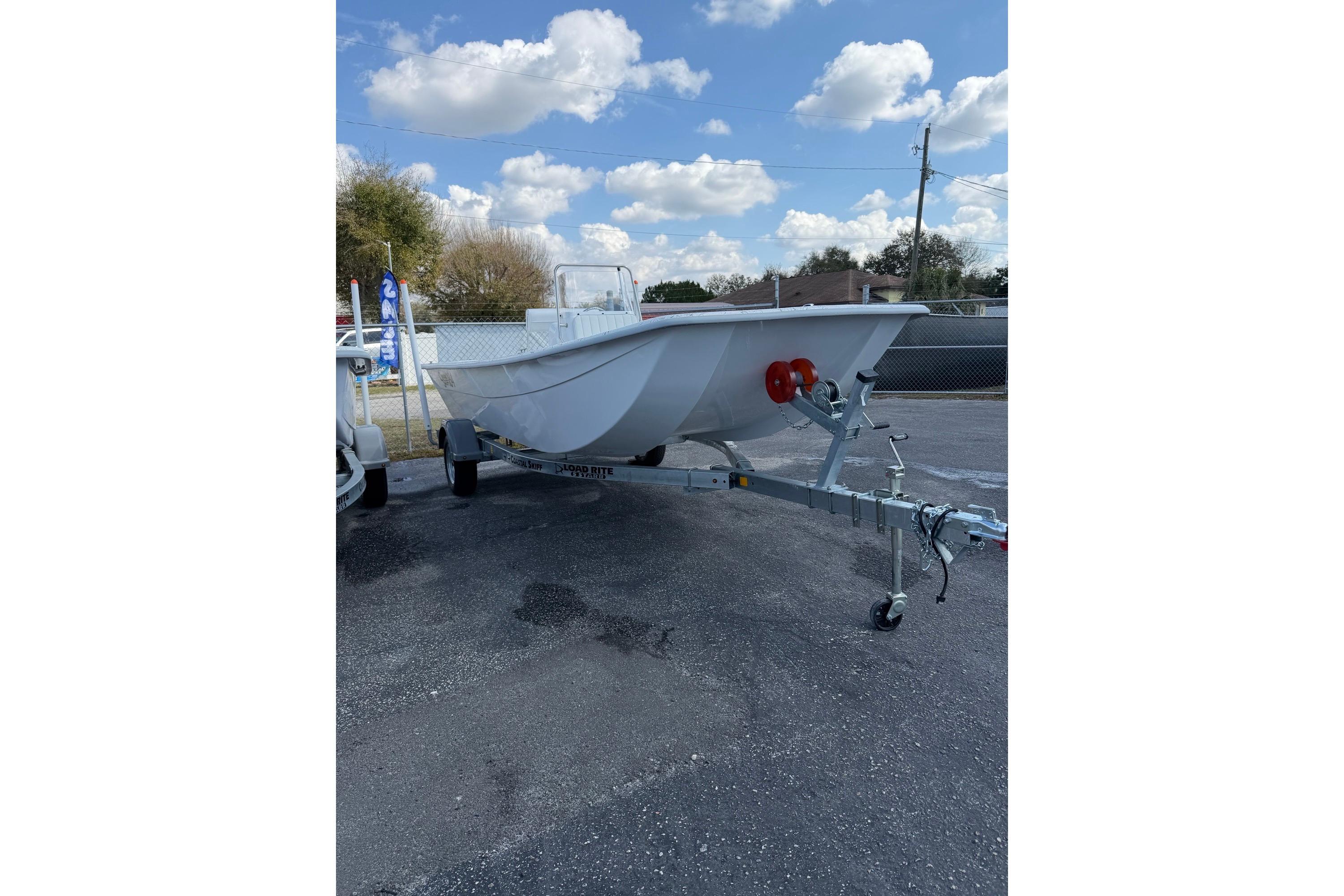 2027 Coastal Skiff 184 boat on trailer under a clear blue sky.