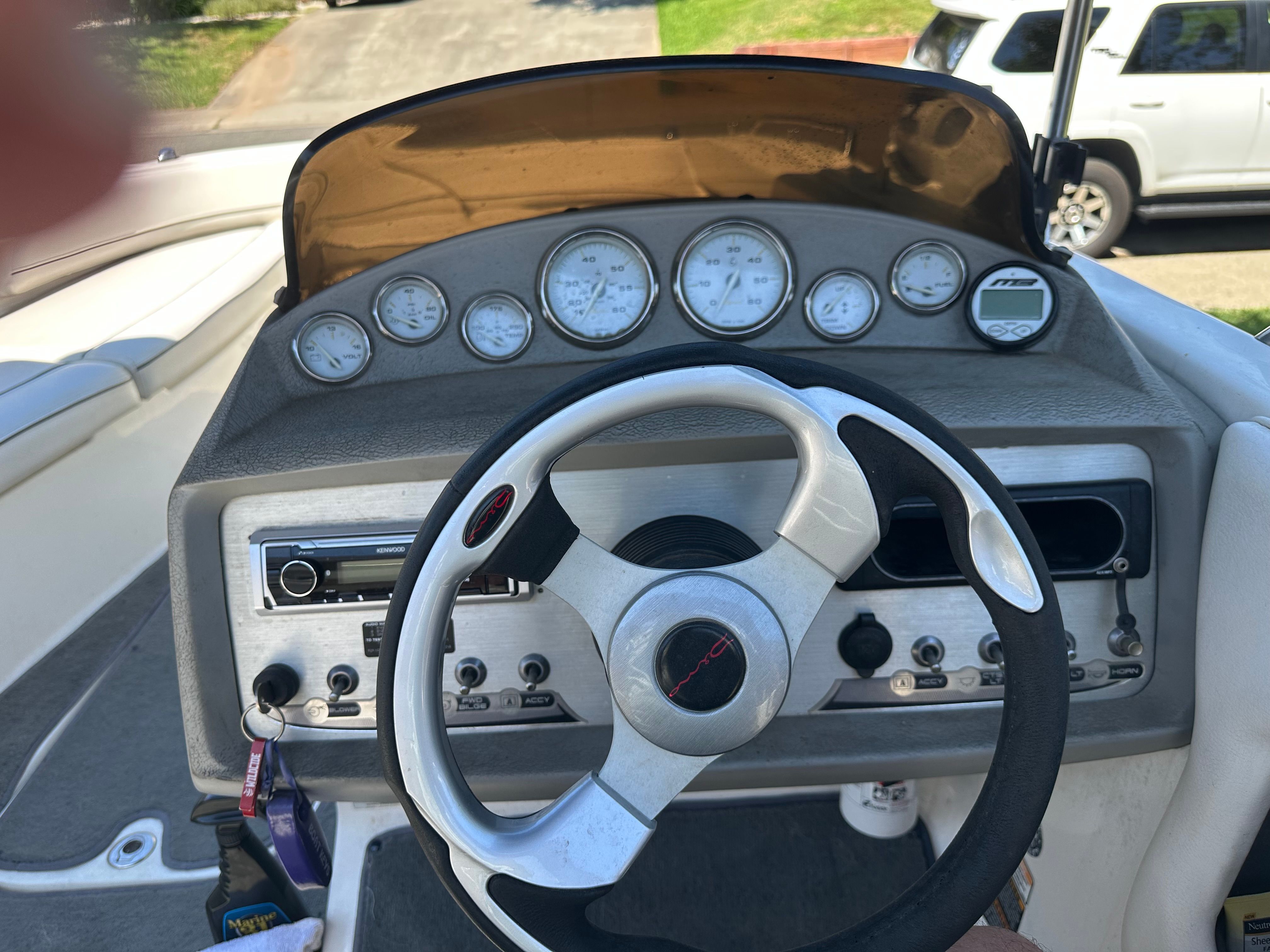 The cockpit of a Bayliner boat with a steering wheel and instrument panel.