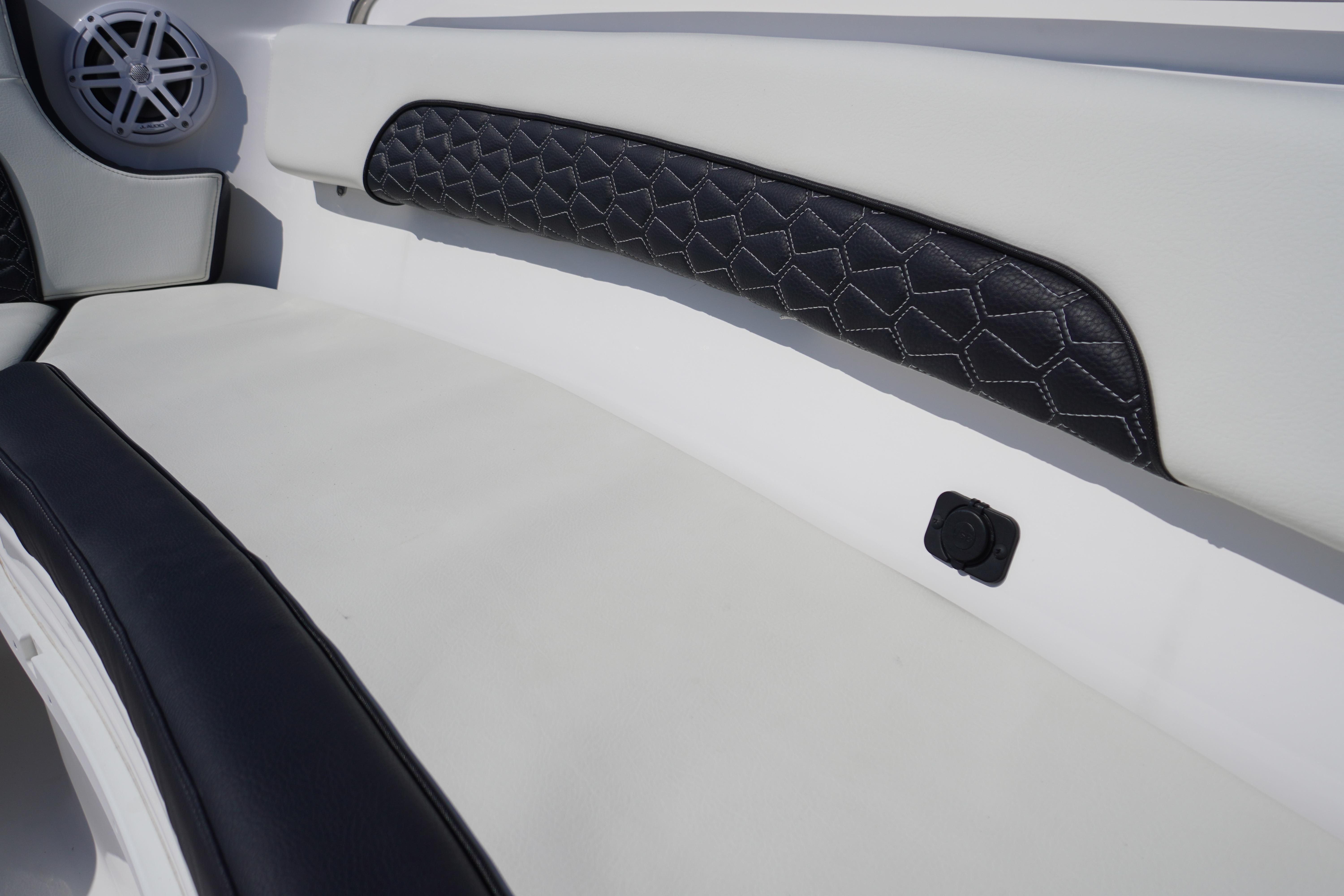 2025 Tidewater 232 SS boat interior with quilted upholstery and speaker detail.
