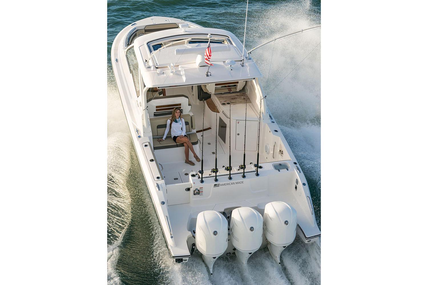 Manufacturer Provided Image: 2025 Pursuit DC 365 Dual Console boat cruising on water with triple engines.