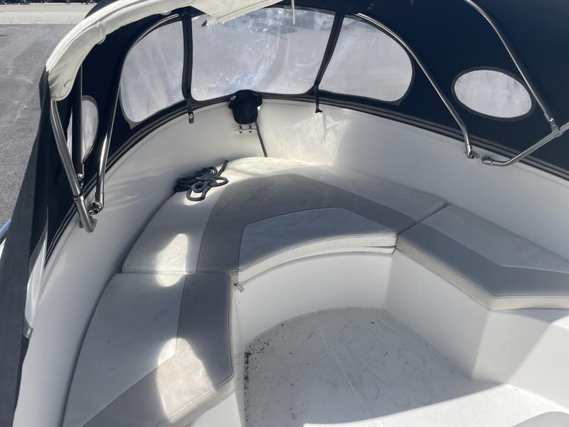 2006 Boston Whaler 210 Outrage boat interior with cushioned seating and canopy.