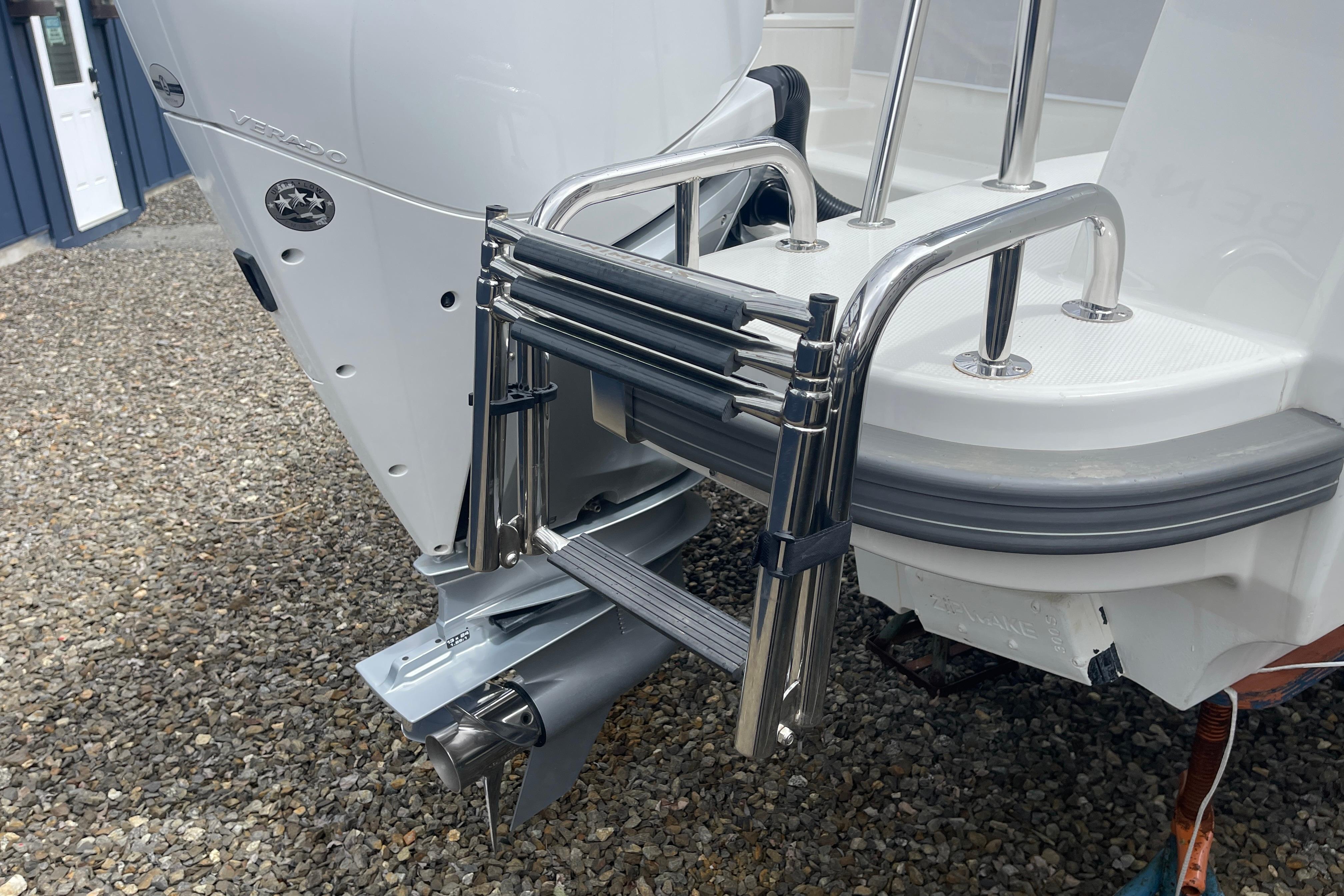 Stainless steel ladder on 2023 Nimbus Tender 8 boat, near outboard motor.