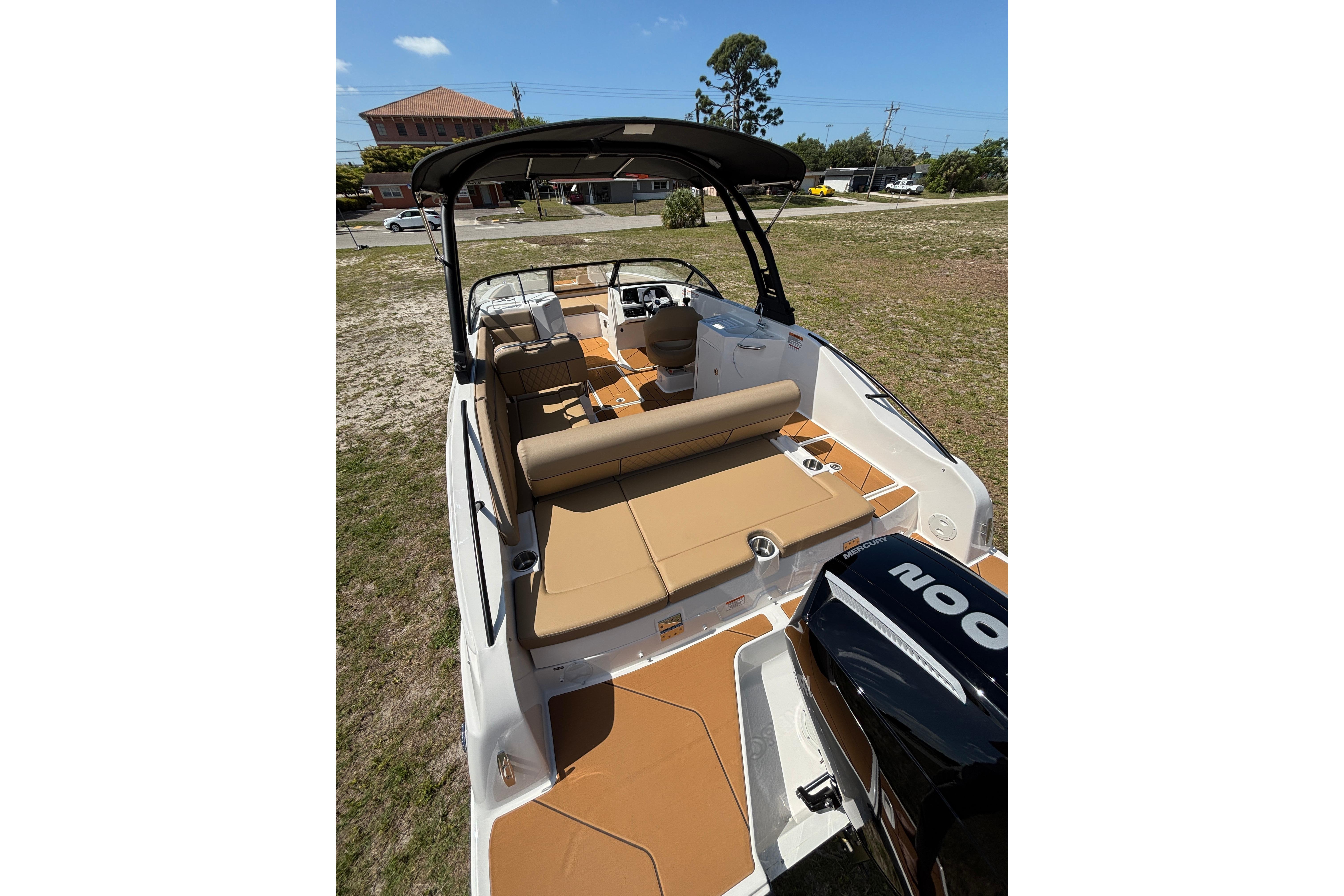 2026 Bayliner D22 boat with tan seating and sleek design, parked on grass.