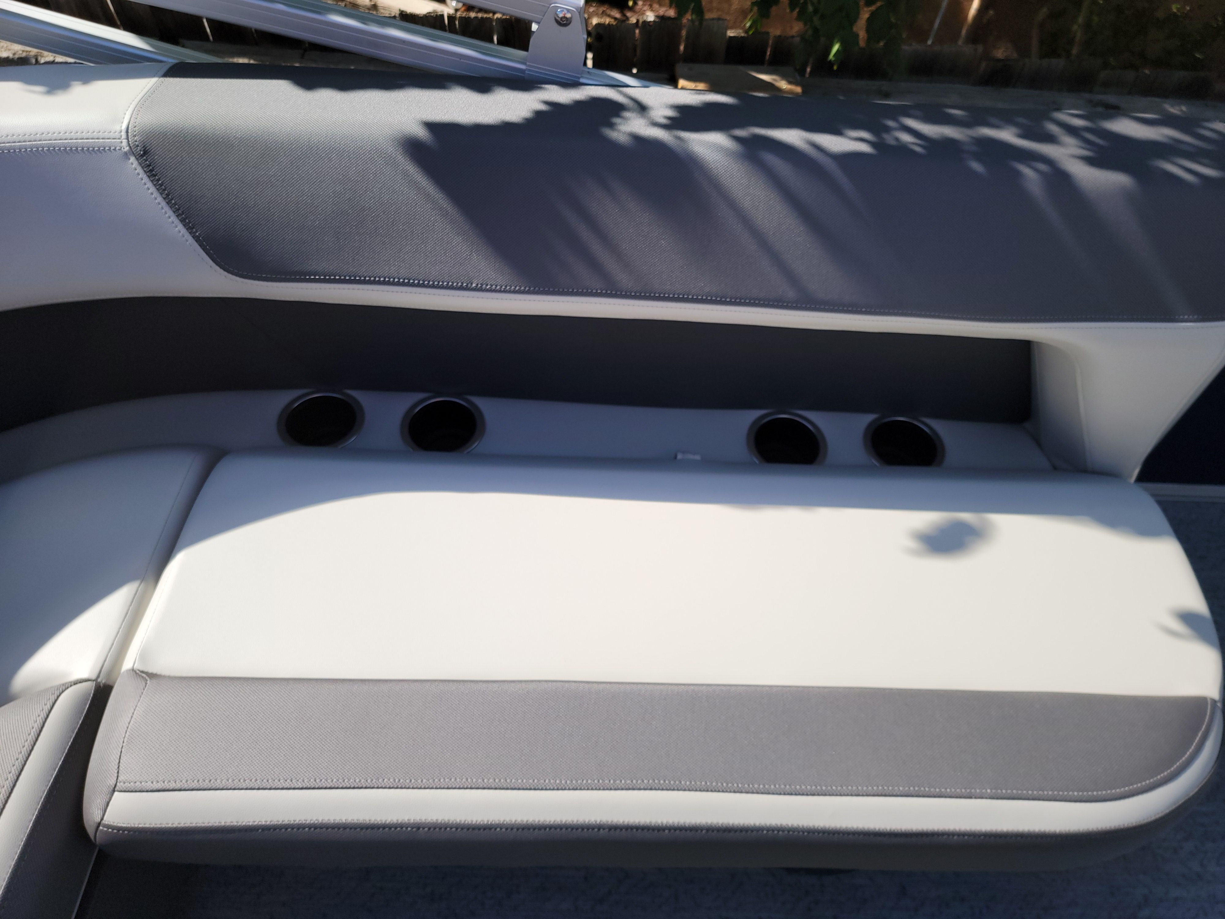 Seating area of a boat with gray and white upholstery.