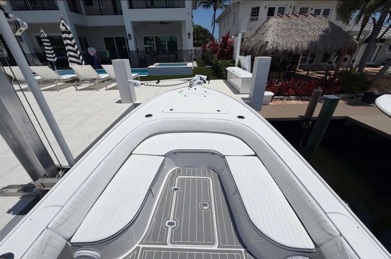 The image shows the bow of a 2016 Contender 25 Bay boat docked at a pier.