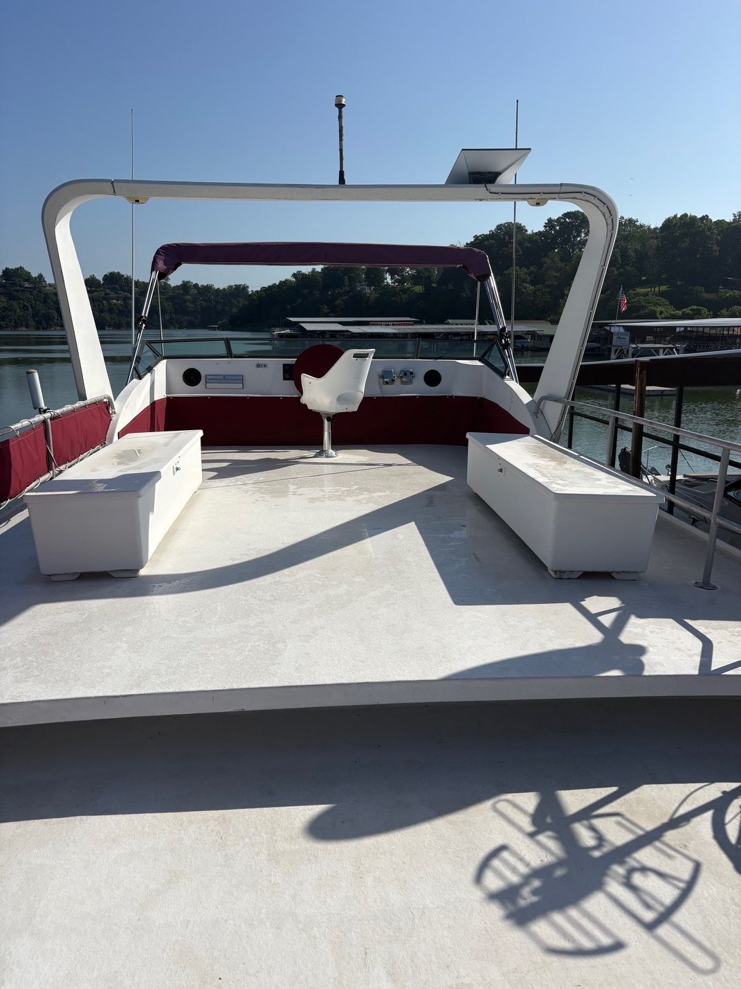 A spacious deck of a 1989 Sumerset houseboat with seating and helm station.
