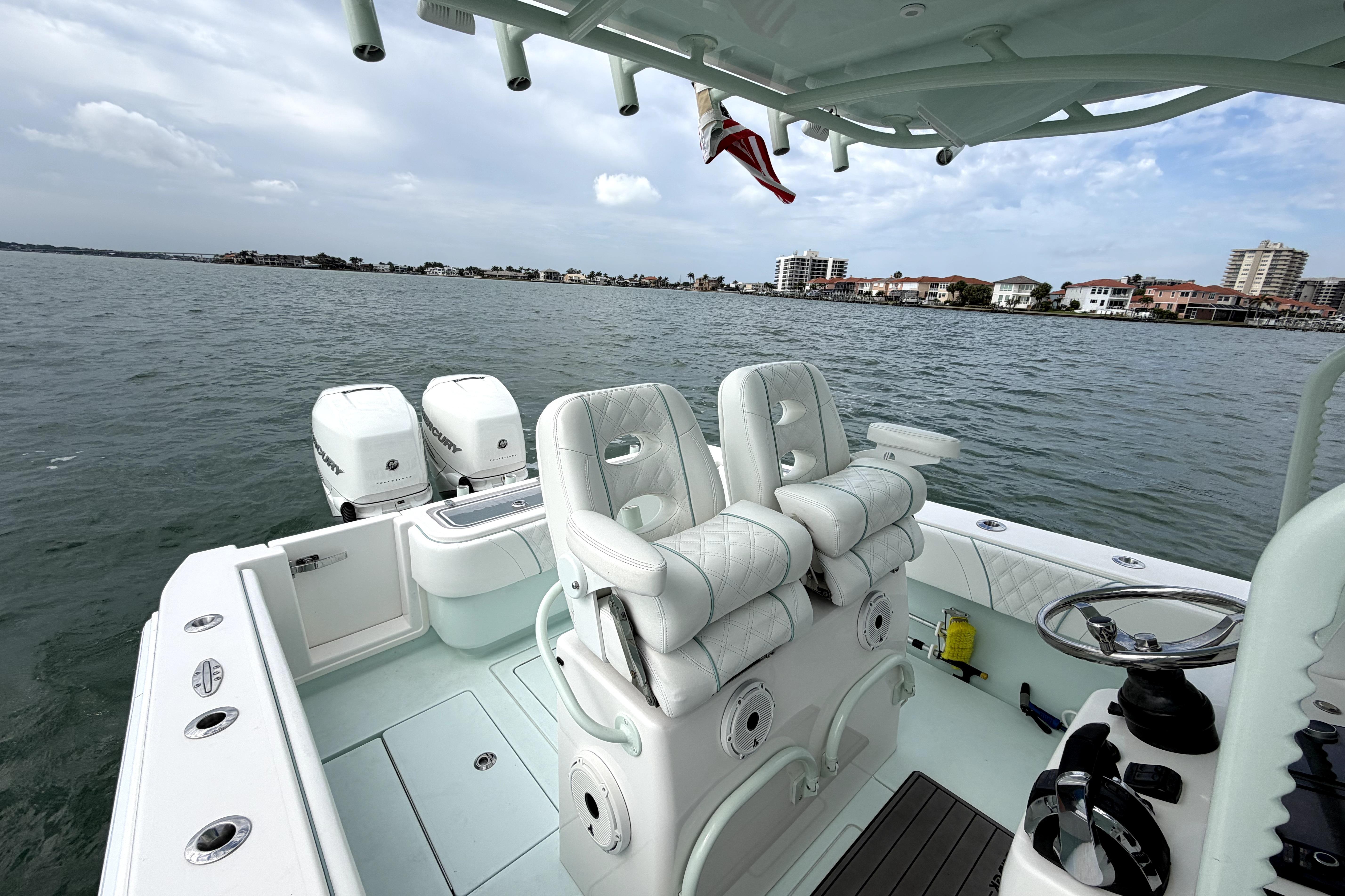 2019 Contender 30 ST boat with dual engines on calm water, featuring luxurious seating.