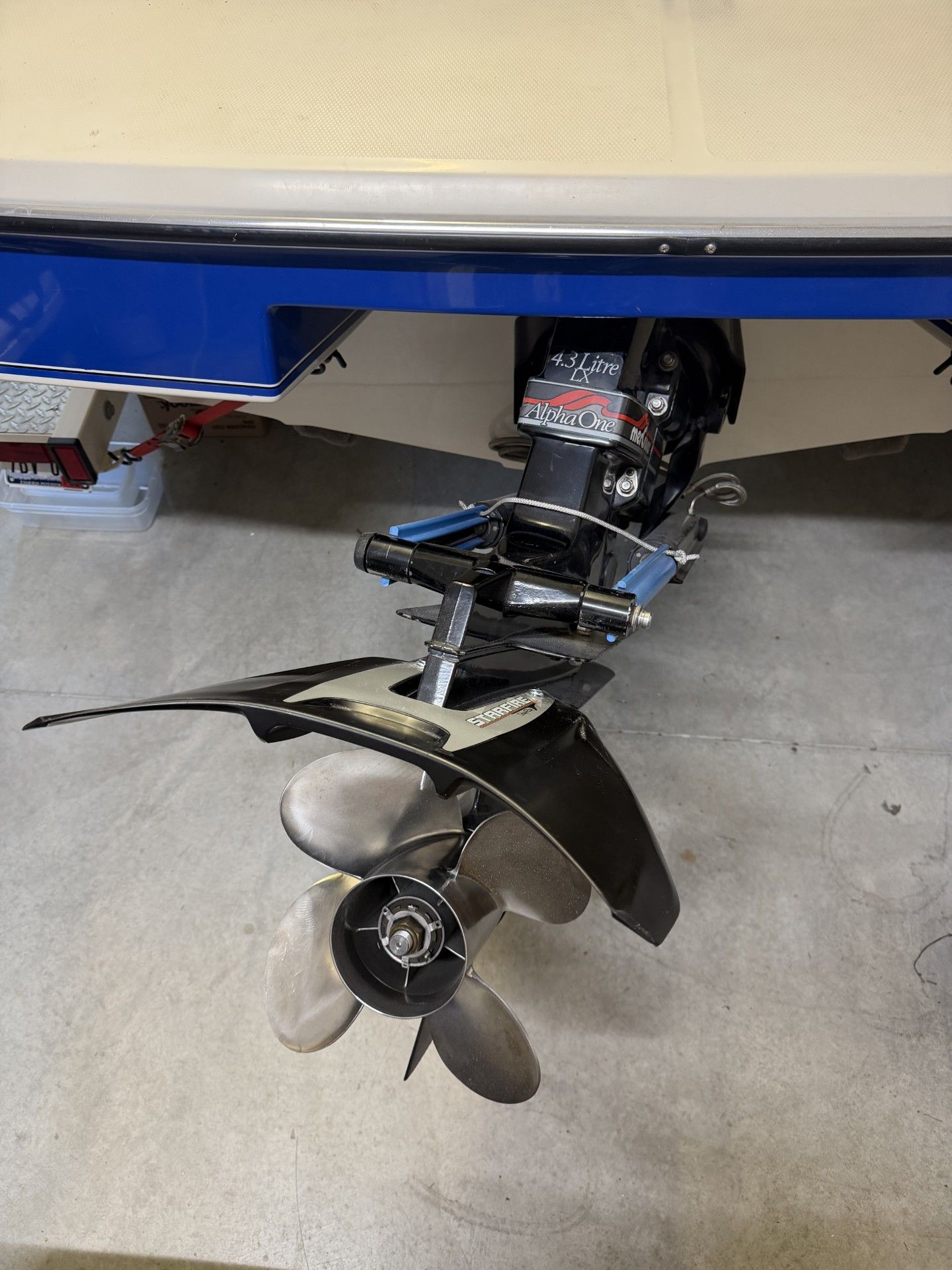 Close-up of a boat motor with propeller, on a trailer in a garage.