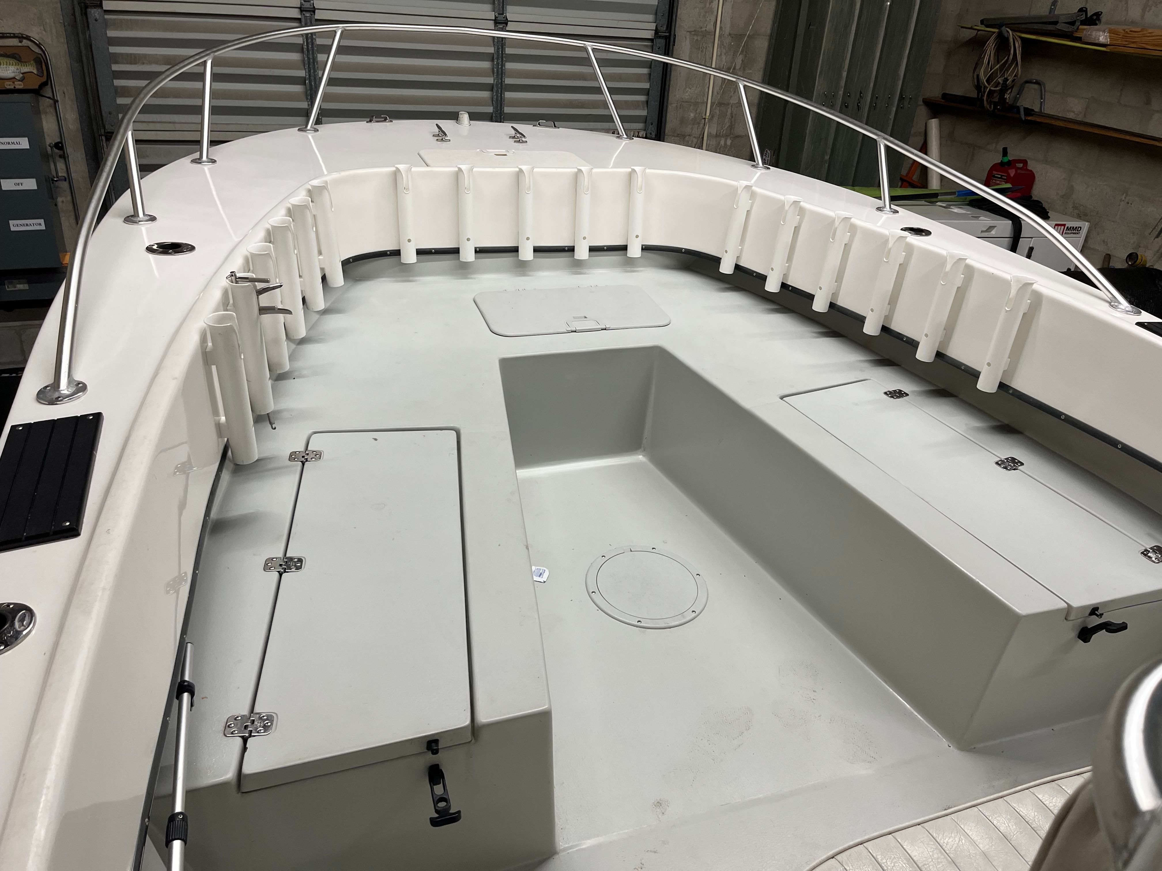 The image shows the deck of a 2002 Dusky 25.6 boat in a storage facility.