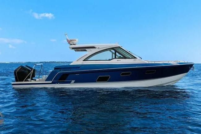 2025 Formula 380 Super Sport Crossover OB boat on open water, under clear blue sky.