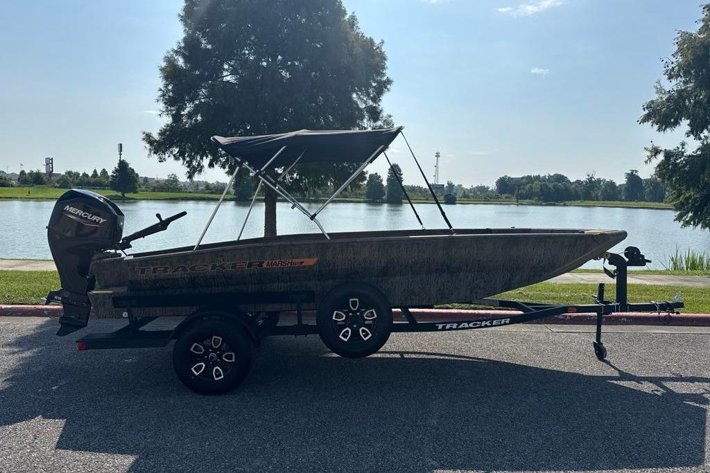 2026 Tracker Grizzly 1756 T Marsh boat on trailer by a lake.