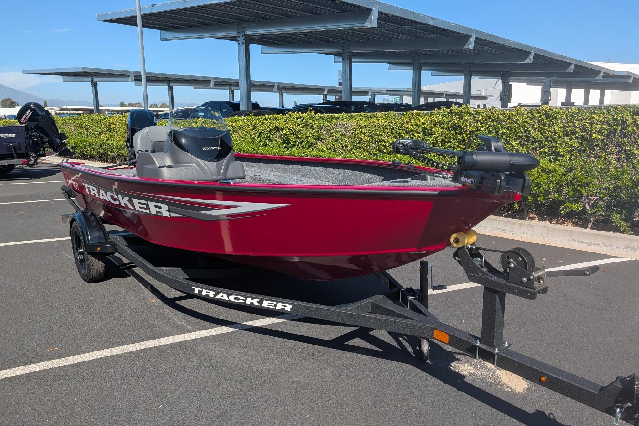 2026 Tracker Super Guide V-16 SC boat in parking lot, vibrant red color.